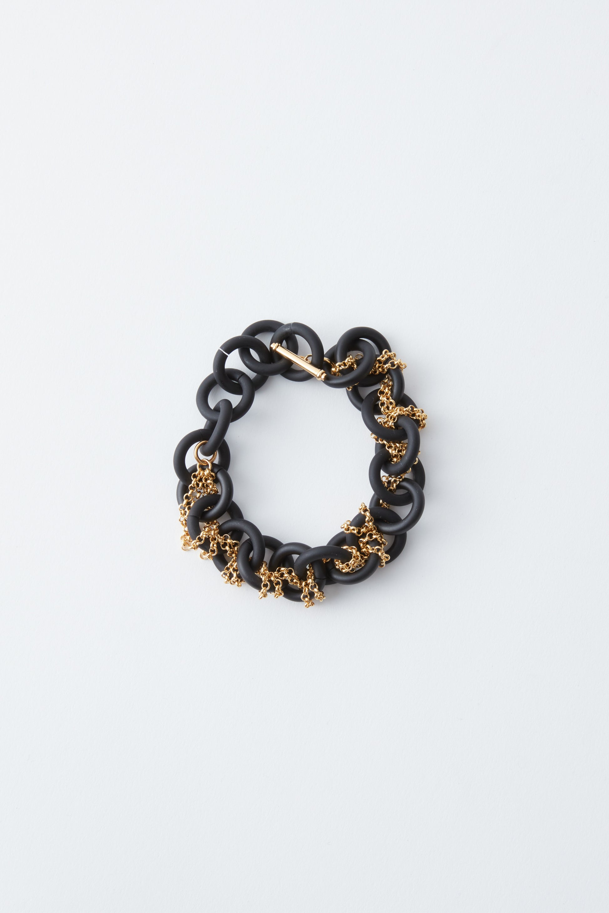 Black and gold chain bracelet on a light gray background