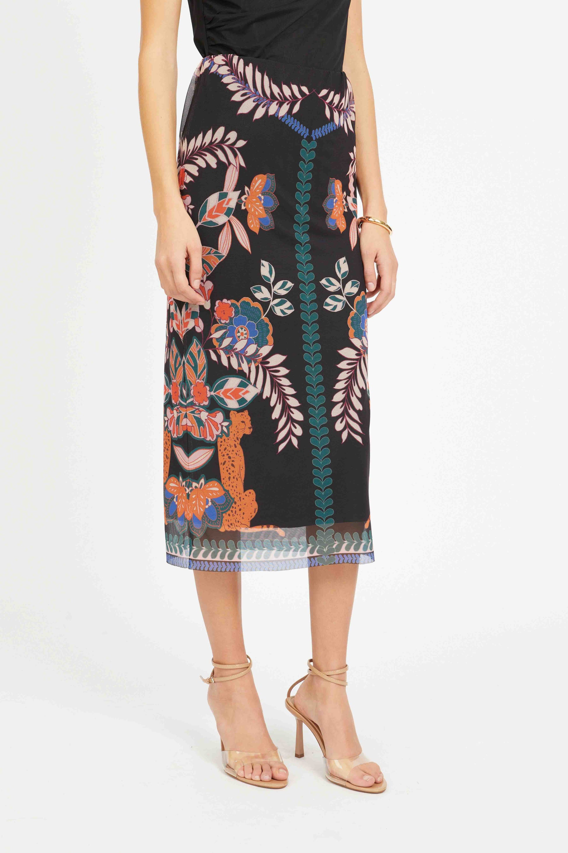 Woman wearing a black skirt with colorful floral pattern on a white background