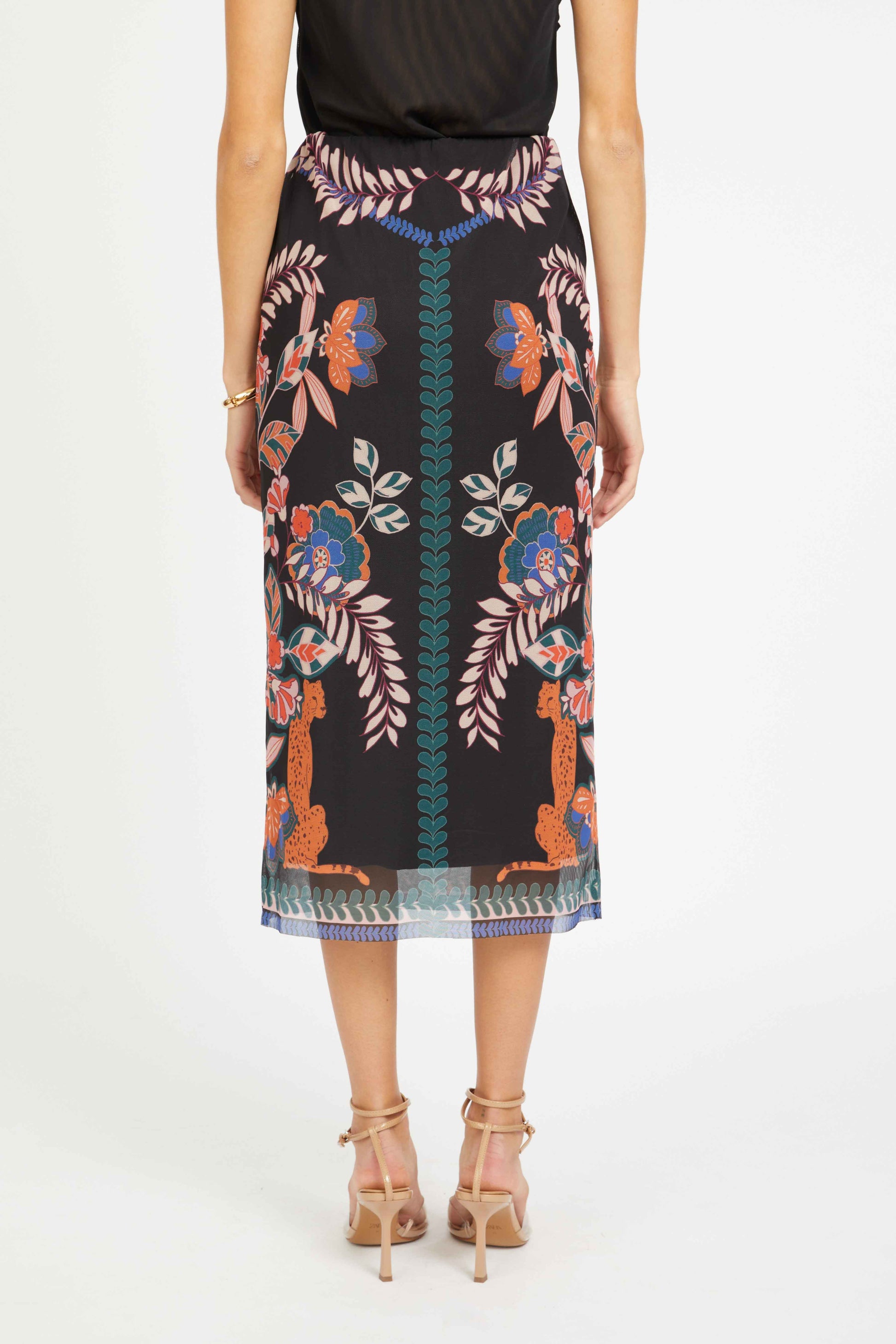 Person wearing a patterned skirt with a white background