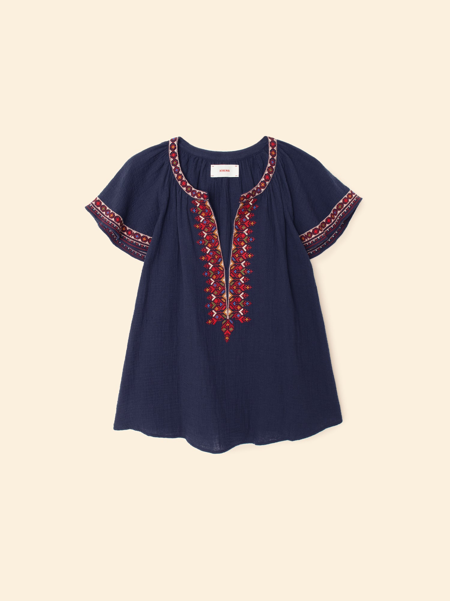 Navy blue blouse with red embroidery on a beige background
