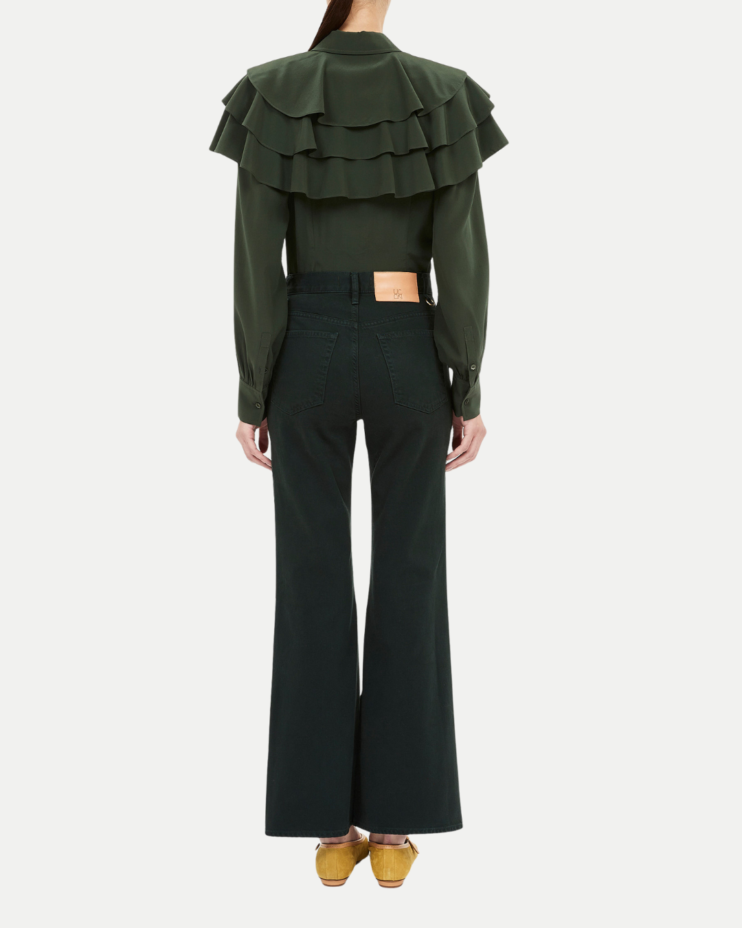 Green ruffled top and black pants on a white background