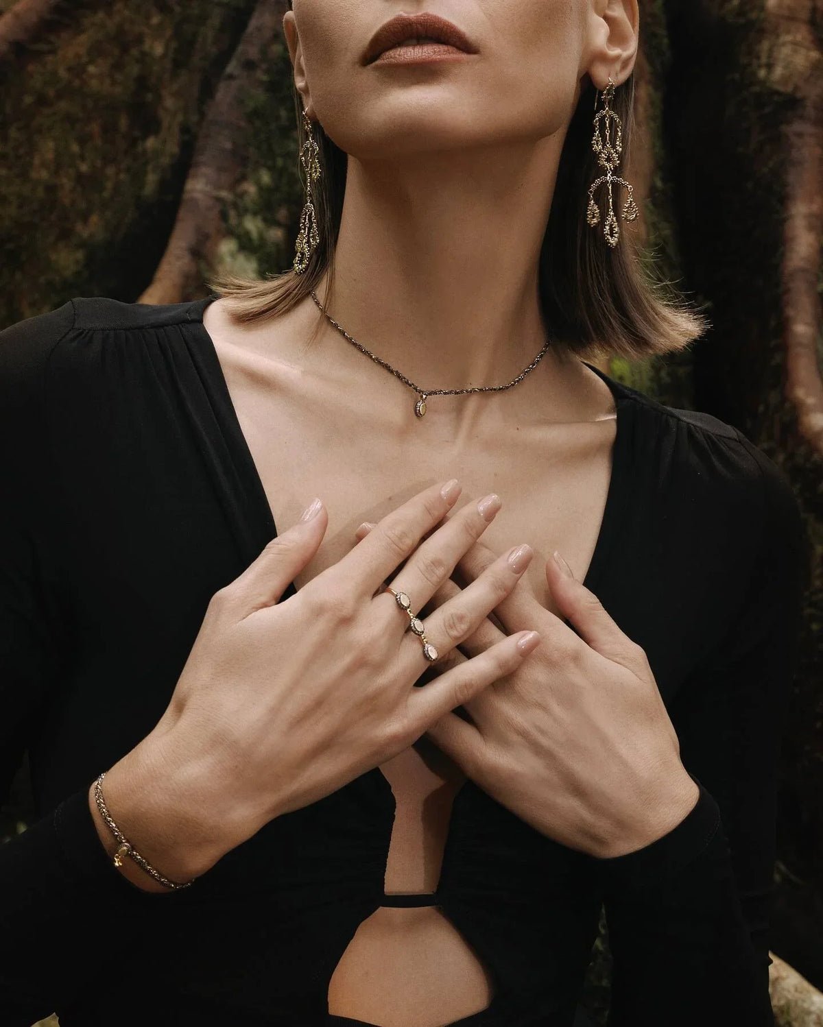 Model wears Marie Laure Chamorel drop earrings, choker, ring and bracelet with crossed hands