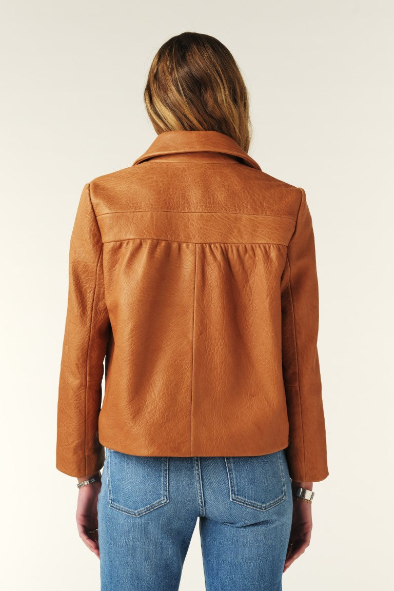 Person wearing a brown leather jacket and blue jeans on a white background