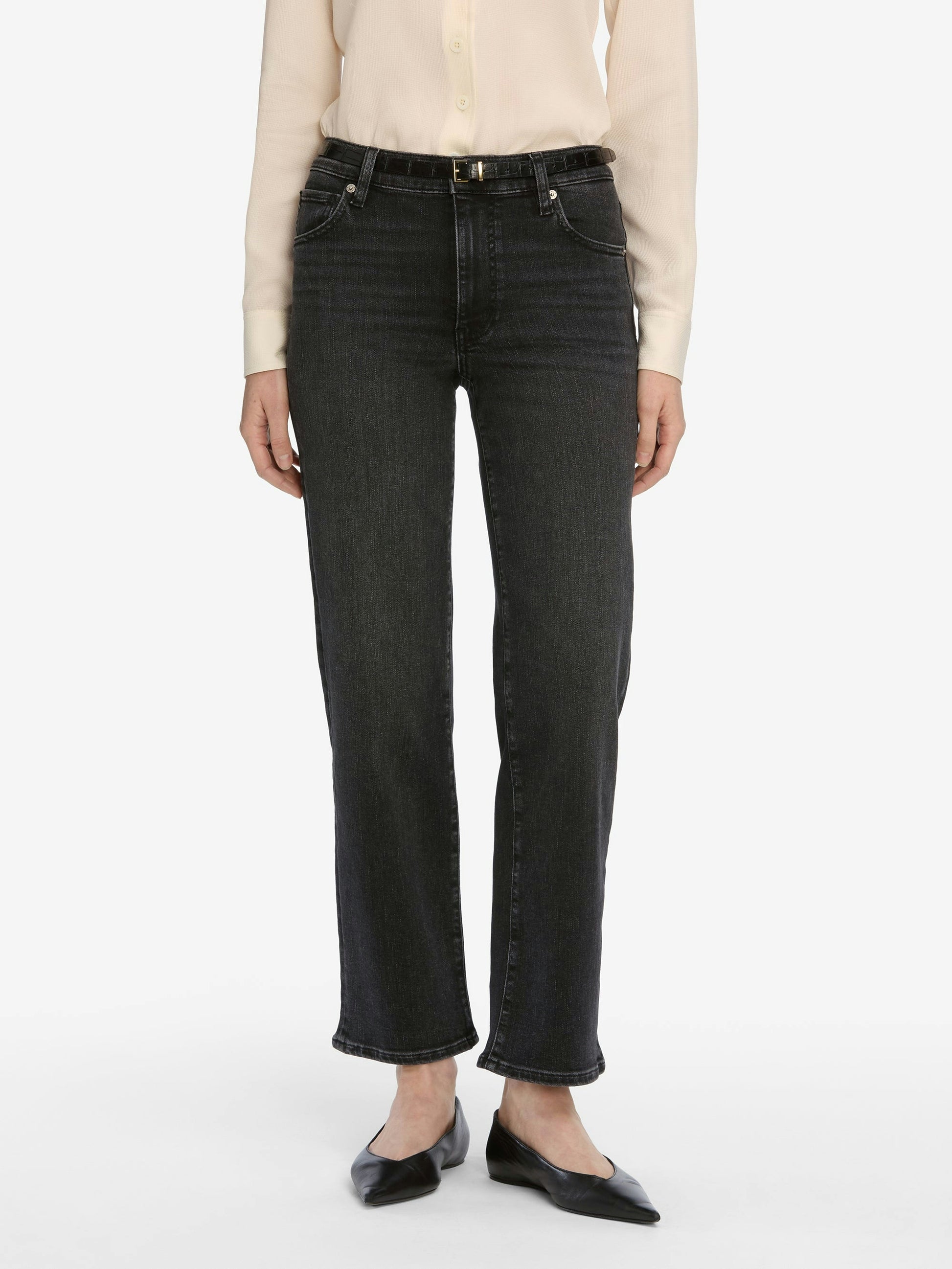 Person wearing black jeans on a white background