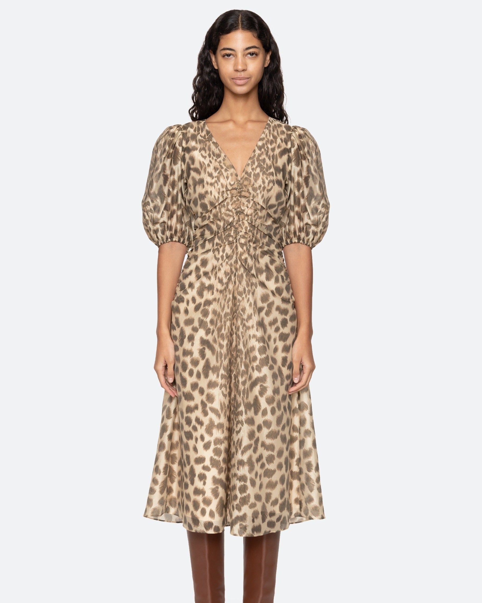 Woman wearing a leopard print dress on a white background