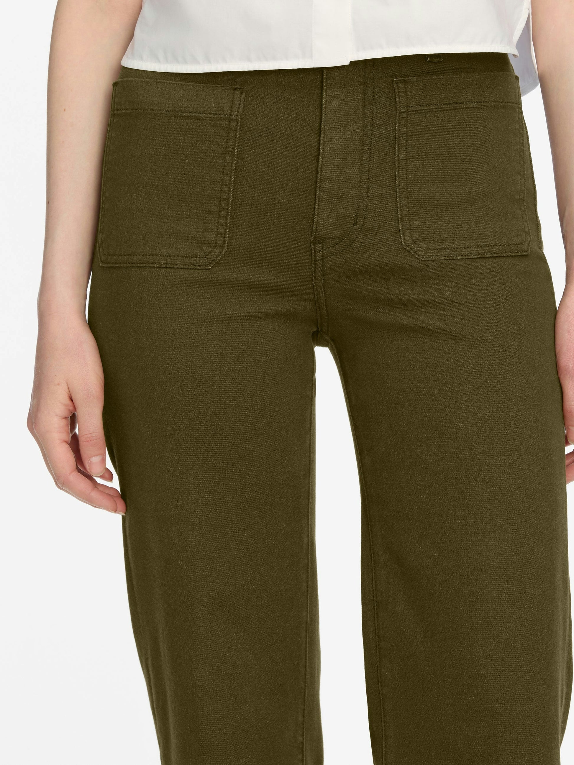 Olive green pants worn by a person on a white background