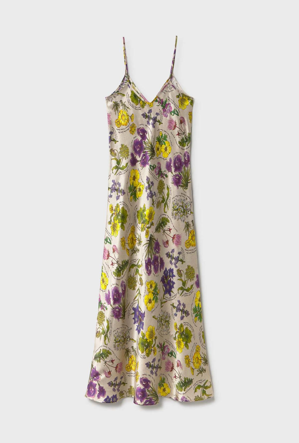 A sleeveless satin slip dress with thin spaghetti straps and a V-neckline, featuring an all-over floral print in purple, yellow, and green on a light beige background, shown against a light gray studio backdrop.