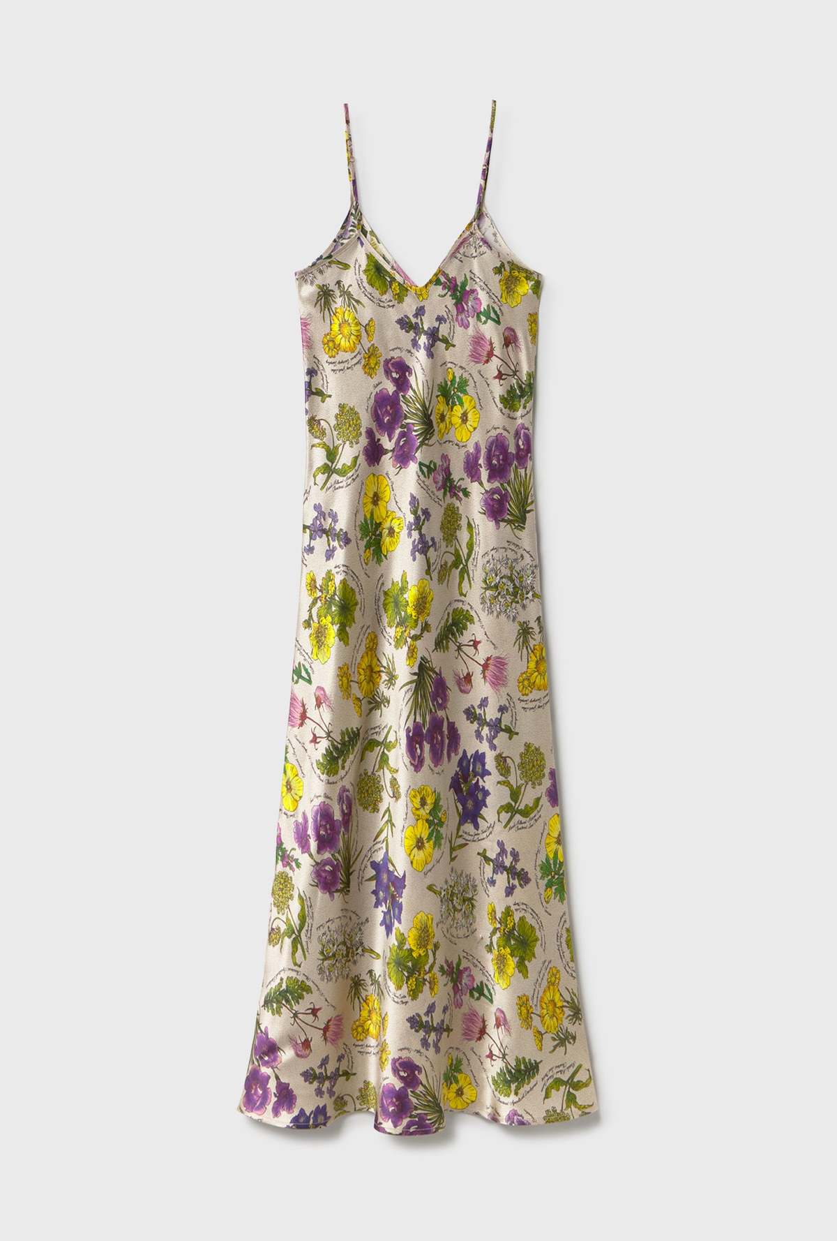 A sleeveless satin slip dress with thin spaghetti straps and a V-neckline, featuring an all-over floral print in purple, yellow, and green on a light beige background, shown against a light gray studio backdrop.