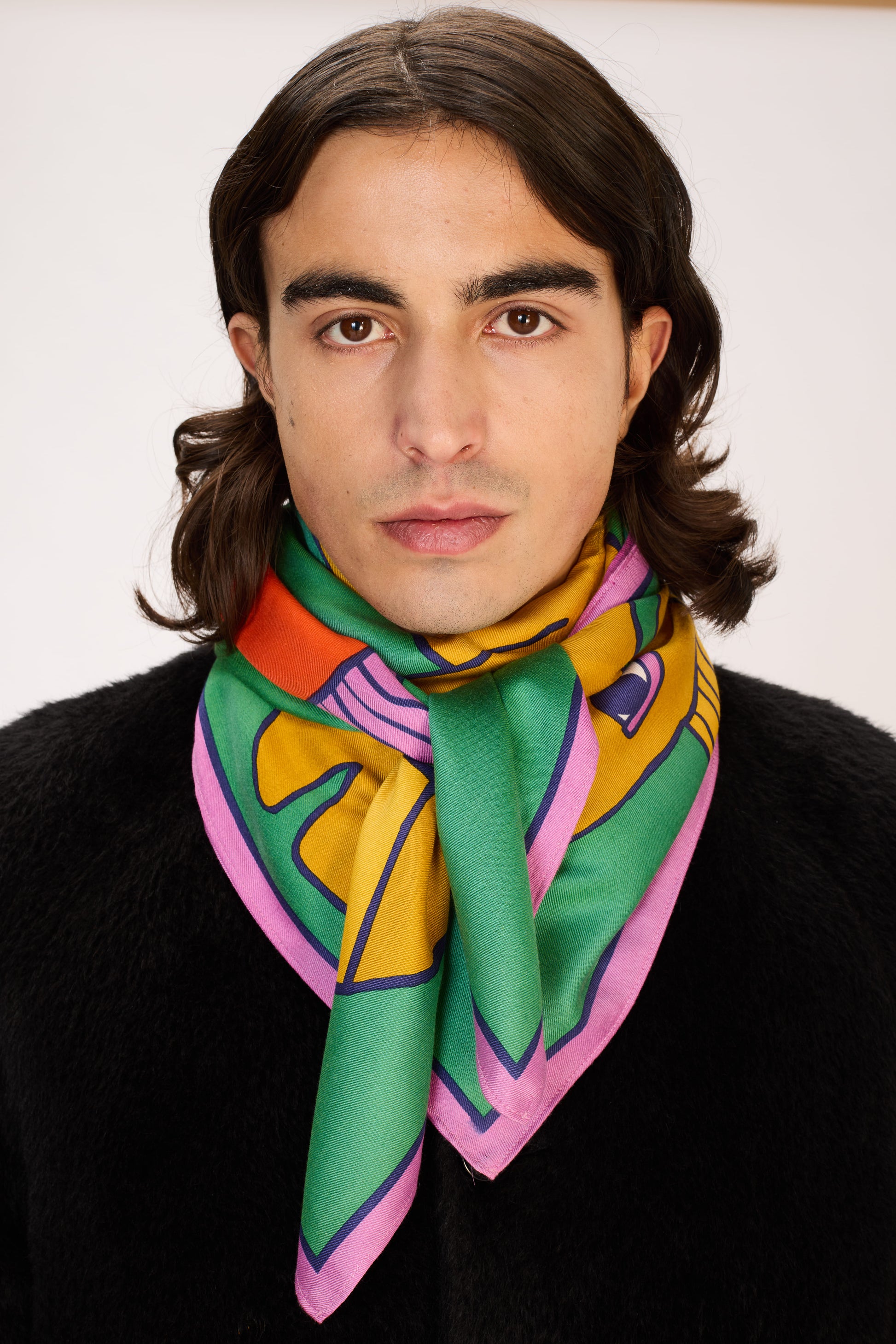 Man wearing a colorful scarf with a black background