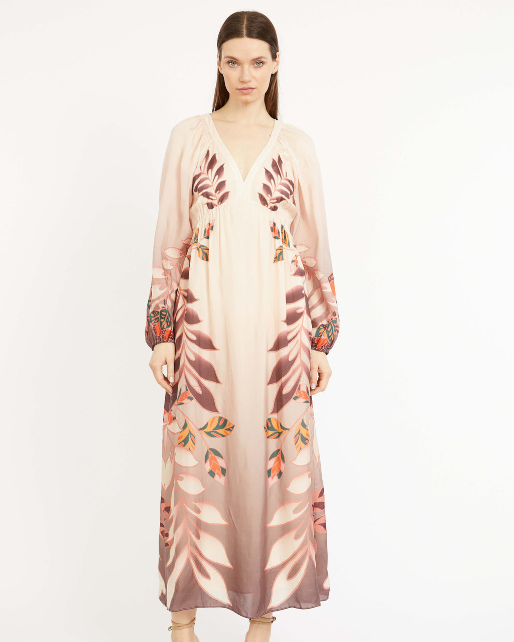 Woman wearing a floral dress with a sheer overlay on a white background