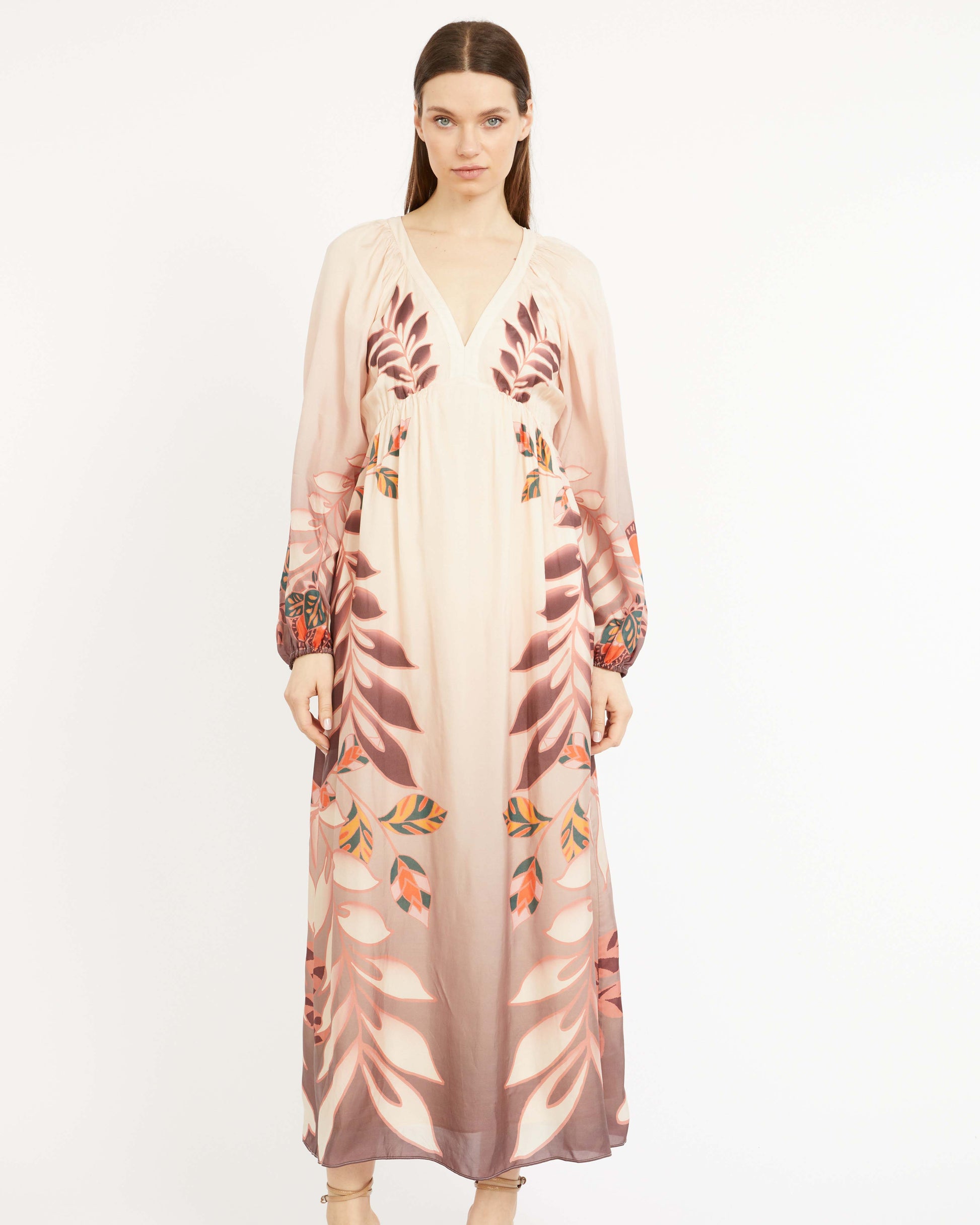 Woman wearing a floral dress with a sheer overlay on a white background