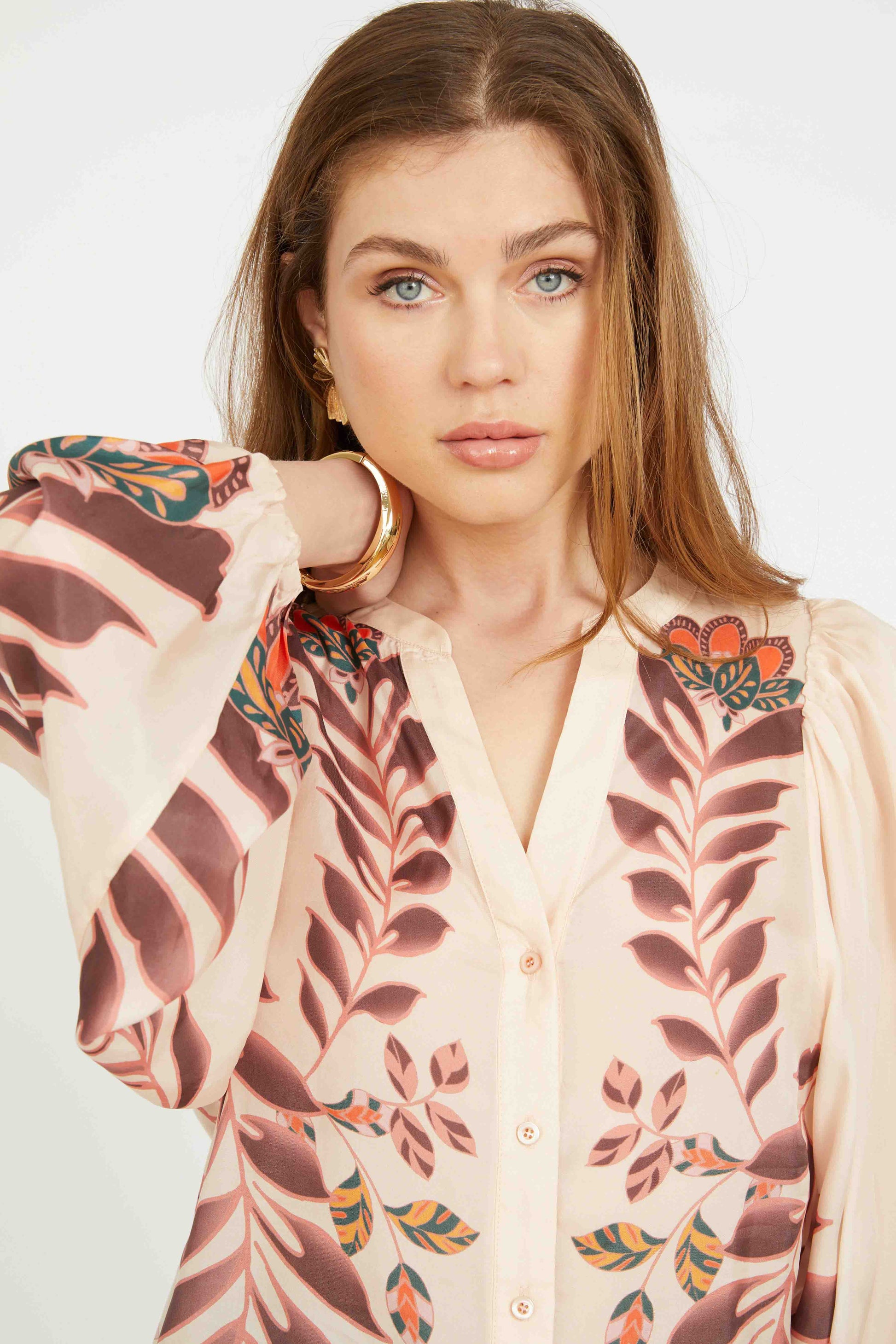 Woman wearing a floral kimono-style garment with a plain background