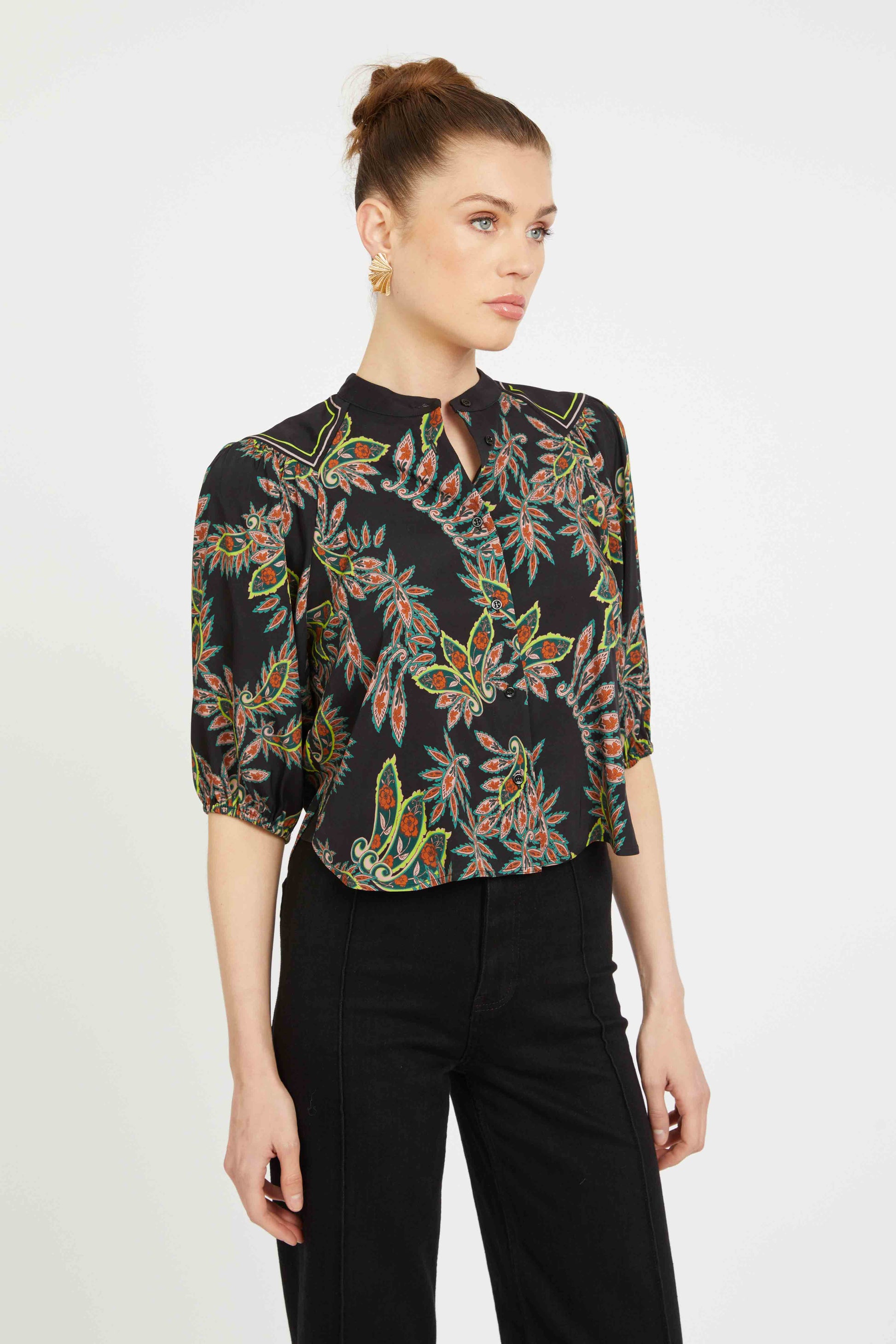 Woman wearing a black floral blouse with a white background