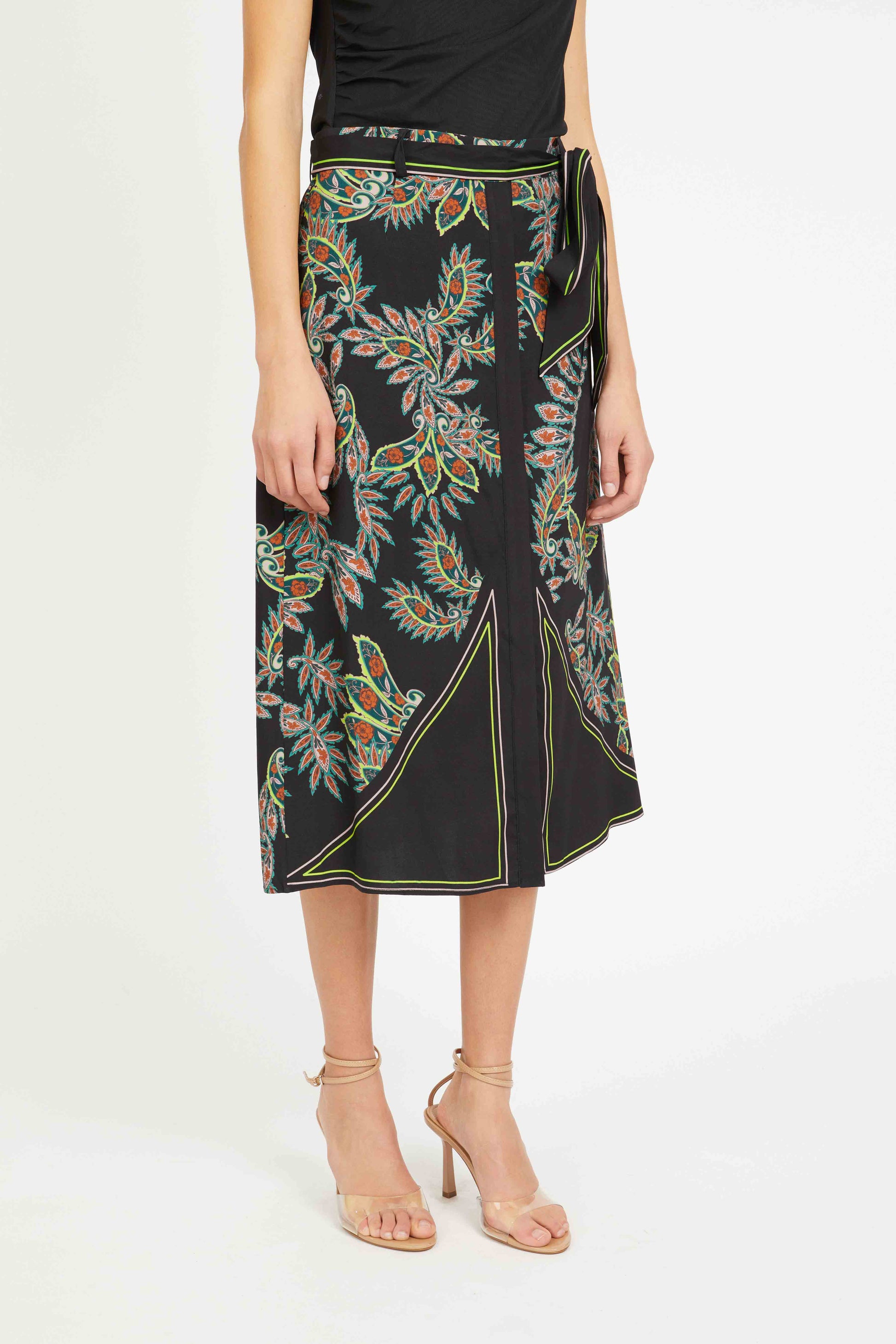 Woman wearing a black skirt with colorful floral patterns on a white background