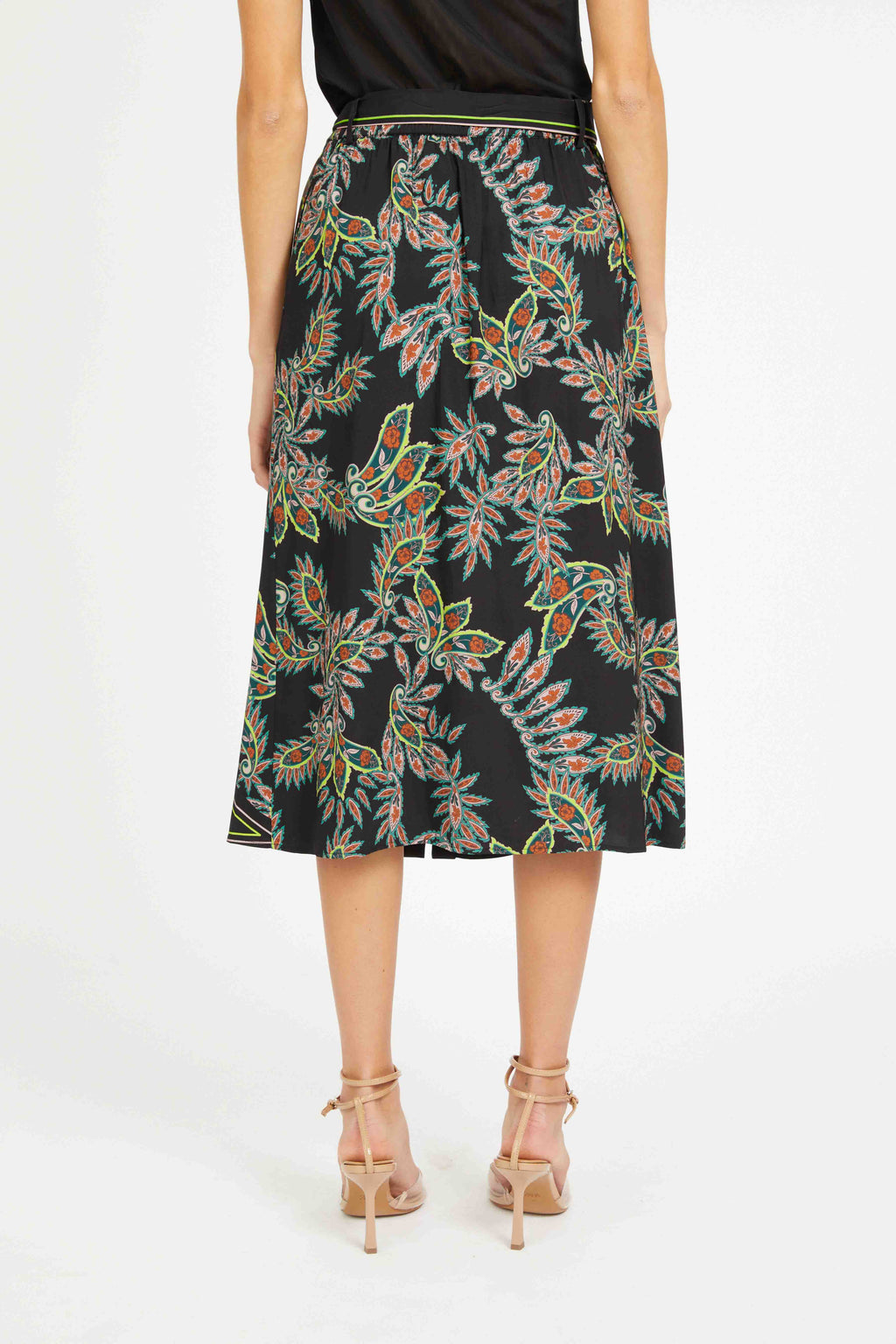 Woman wearing a black floral patterned skirt on a white background