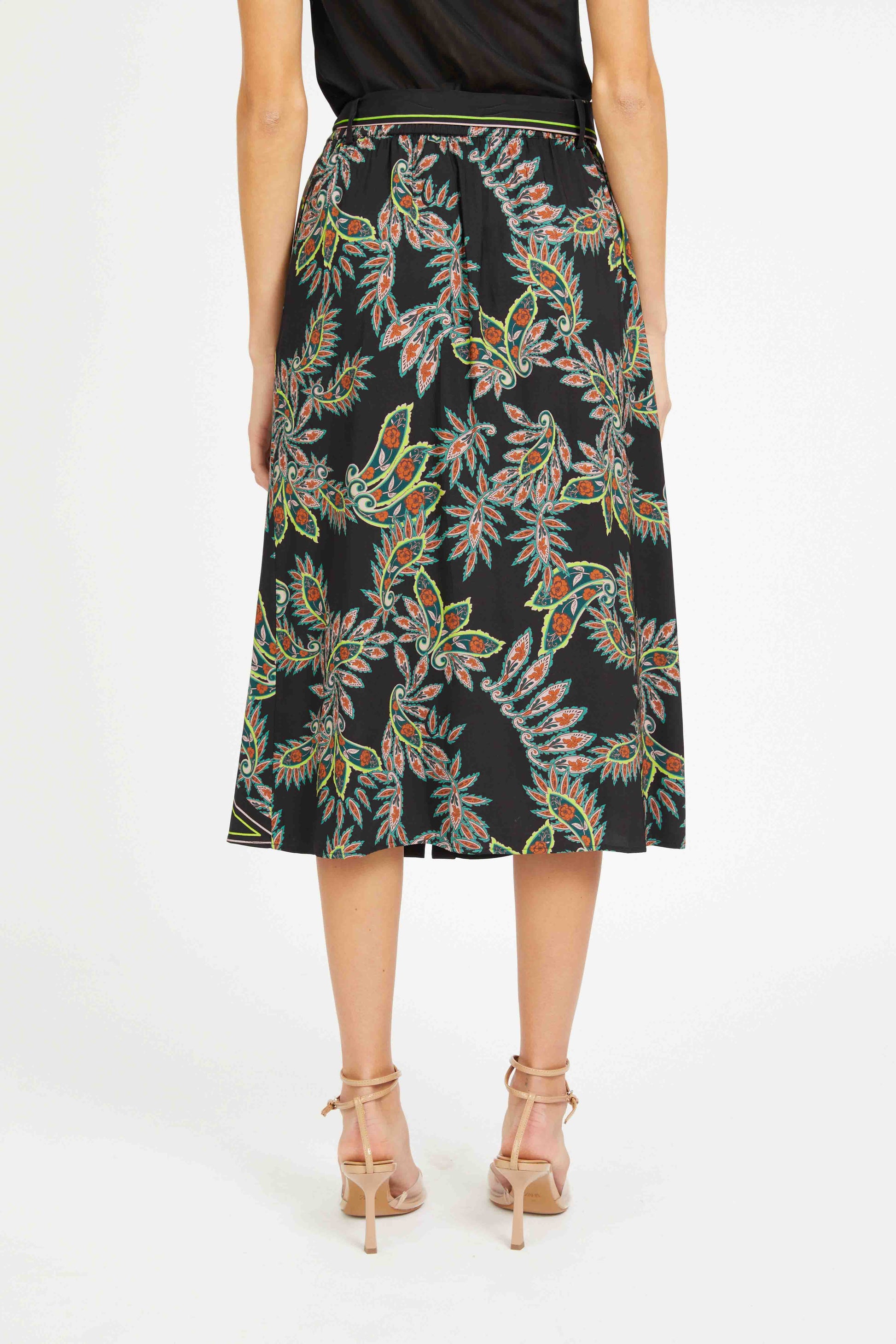 Woman wearing a black floral patterned skirt on a white background