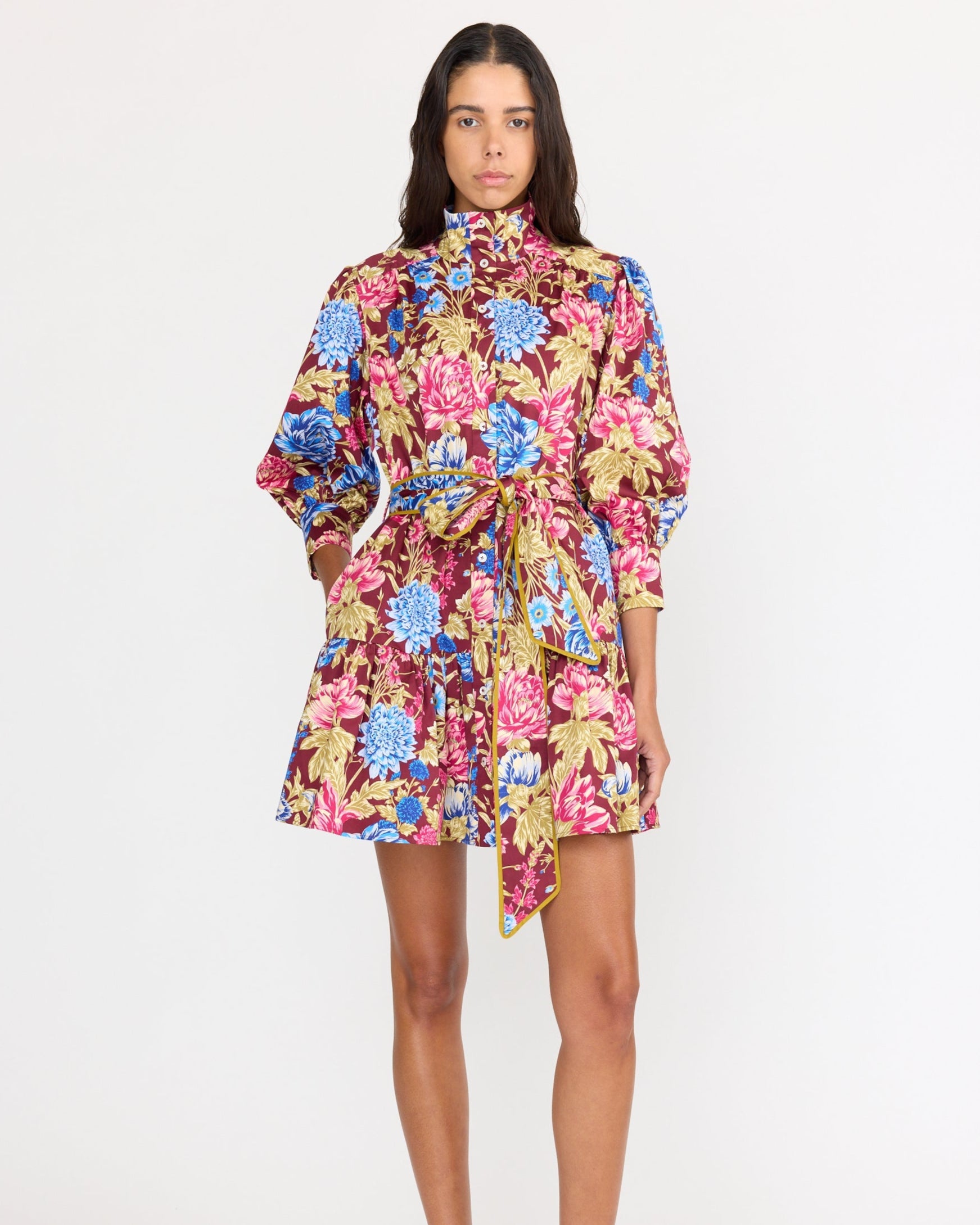 Woman wearing a colorful floral dress on a white background