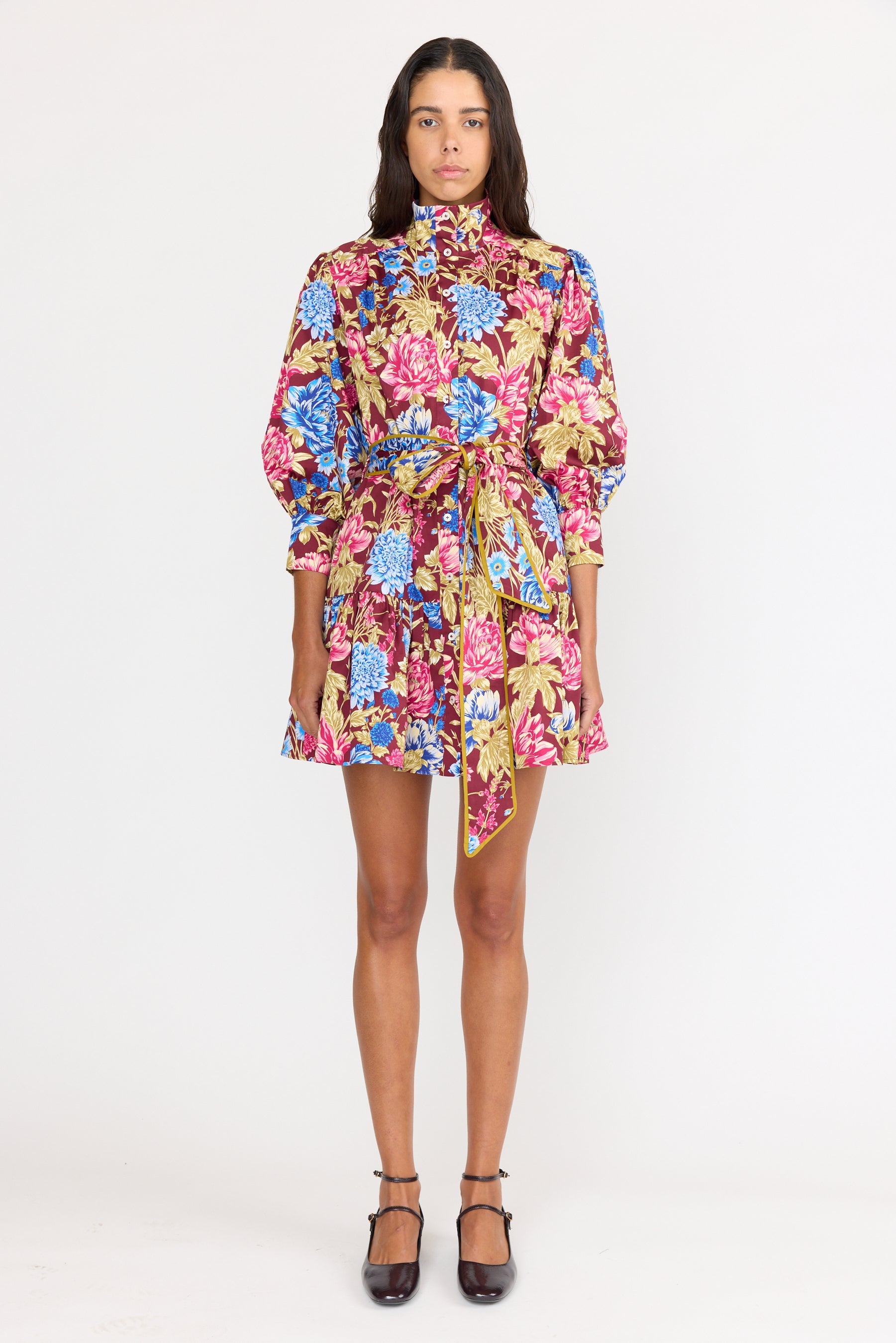 Woman wearing a colorful floral dress on a white background