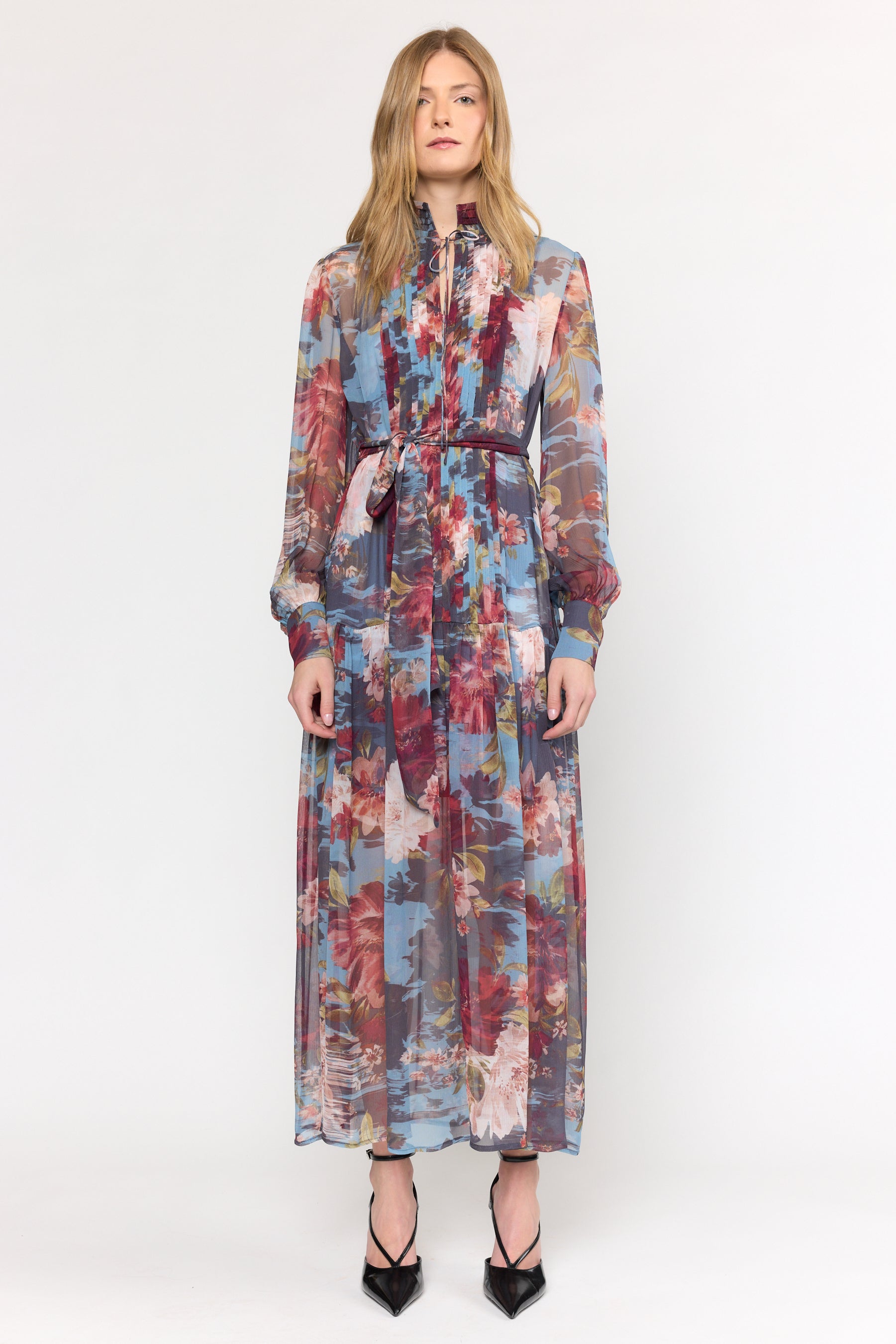 Woman wearing a long floral dress on a white background