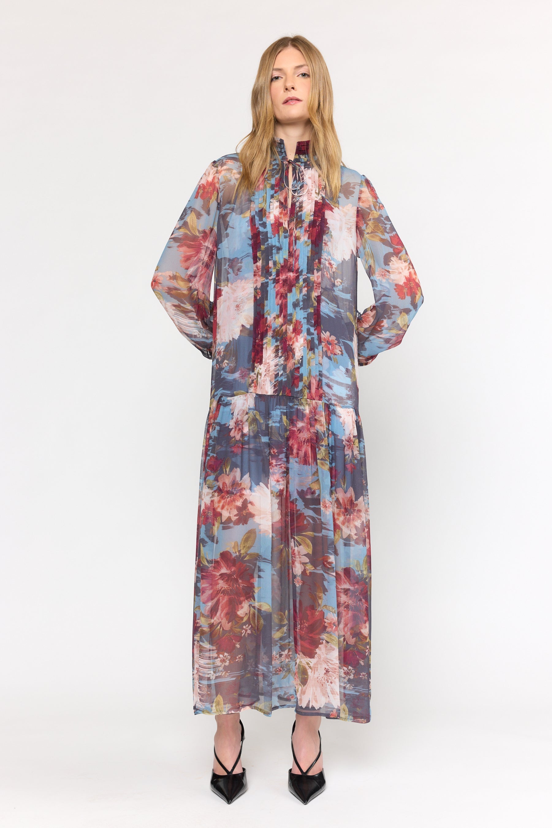 Woman wearing a long floral dress on a white background
