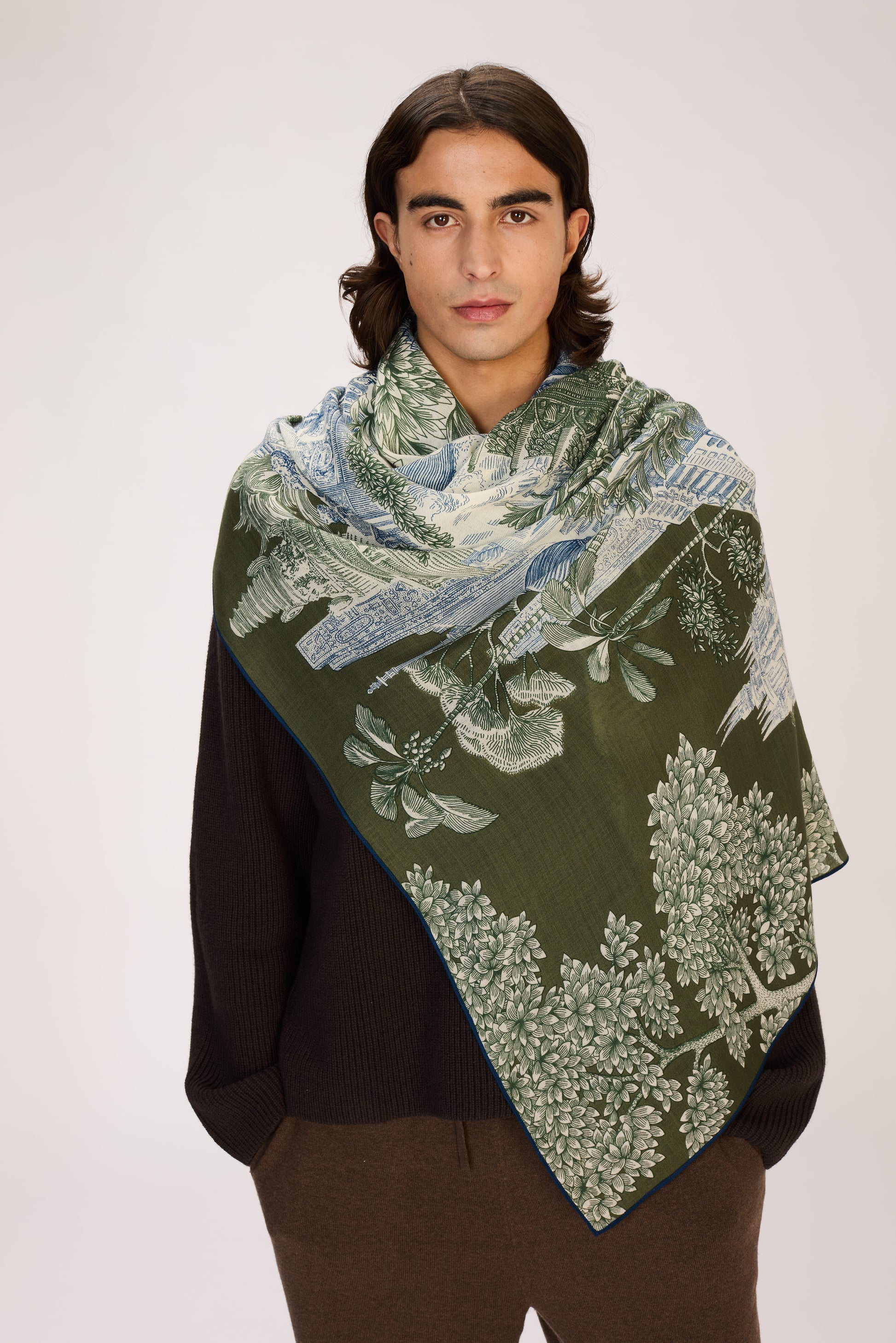 Man wearing a green patterned scarf on a white background