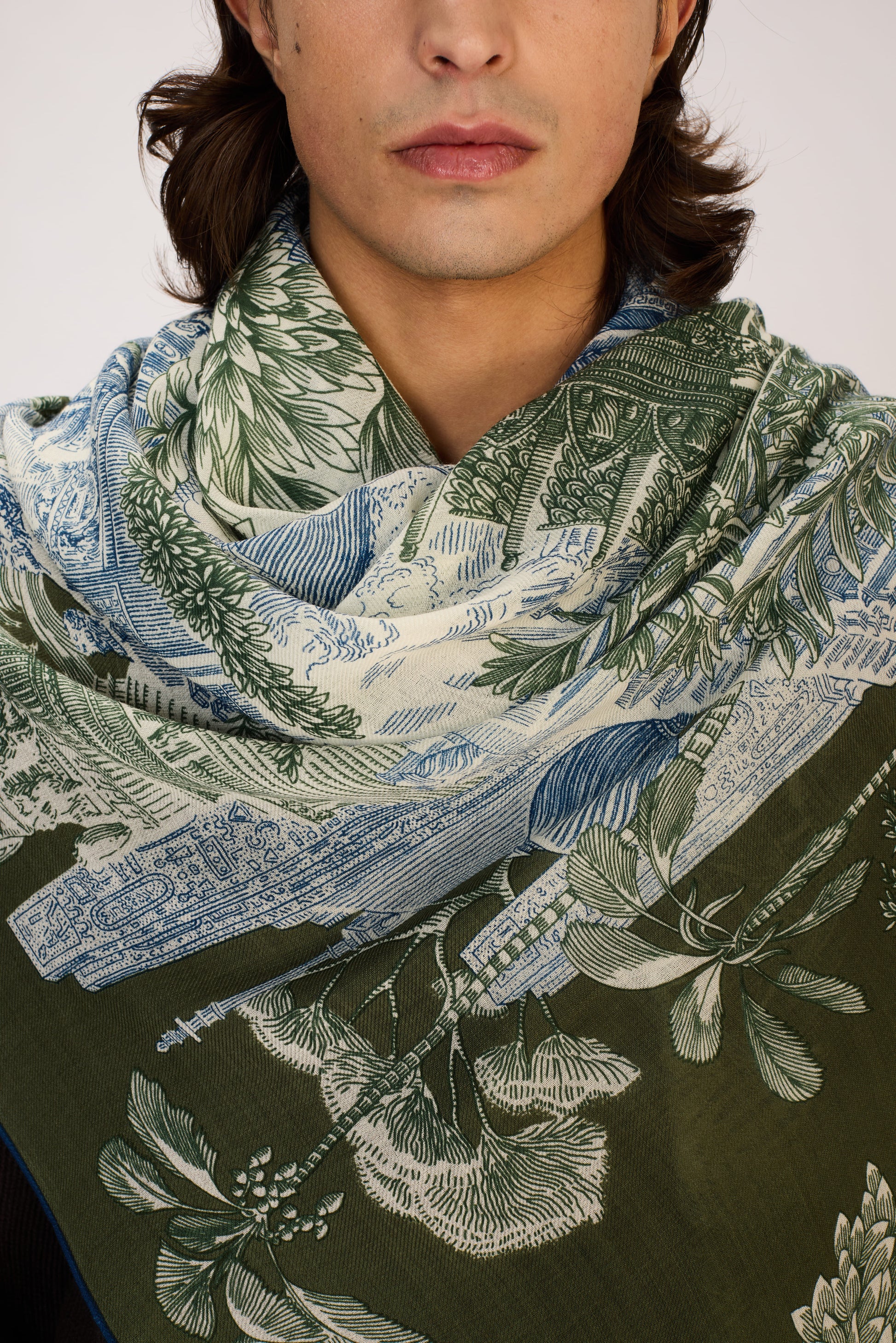 Person wearing a patterned scarf with a neutral background