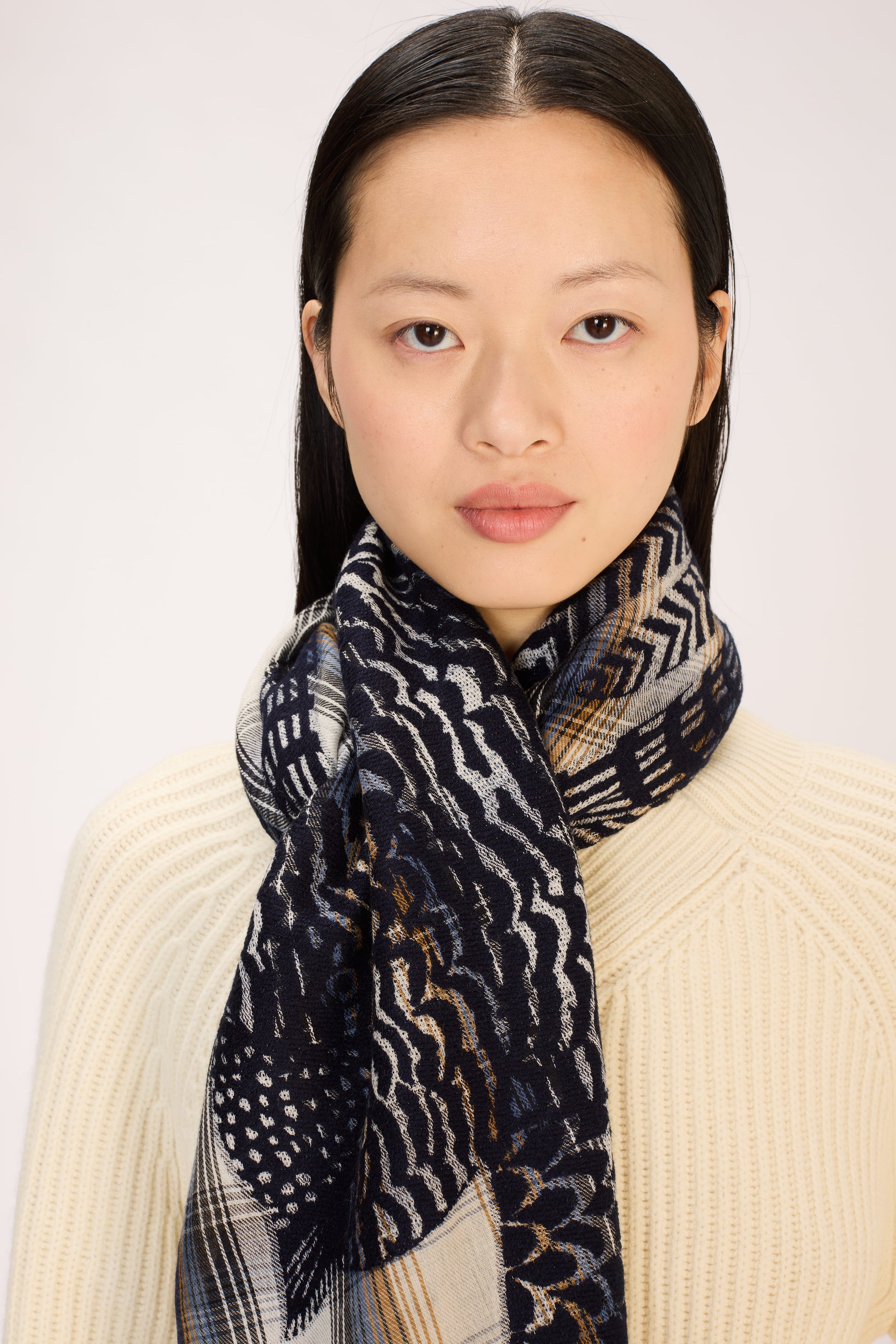 Woman wearing a patterned scarf with a plain background
