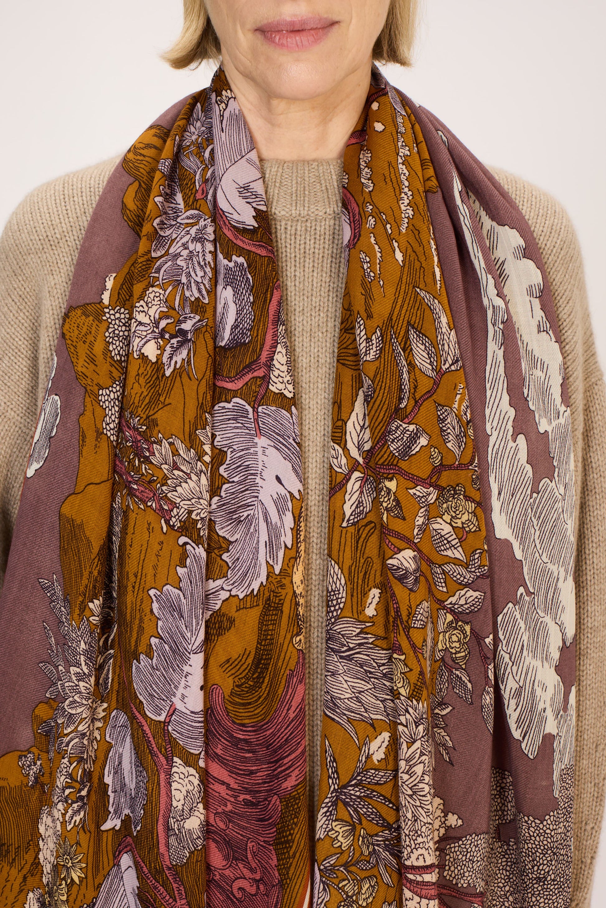 Woman wearing a patterned scarf with a neutral background
