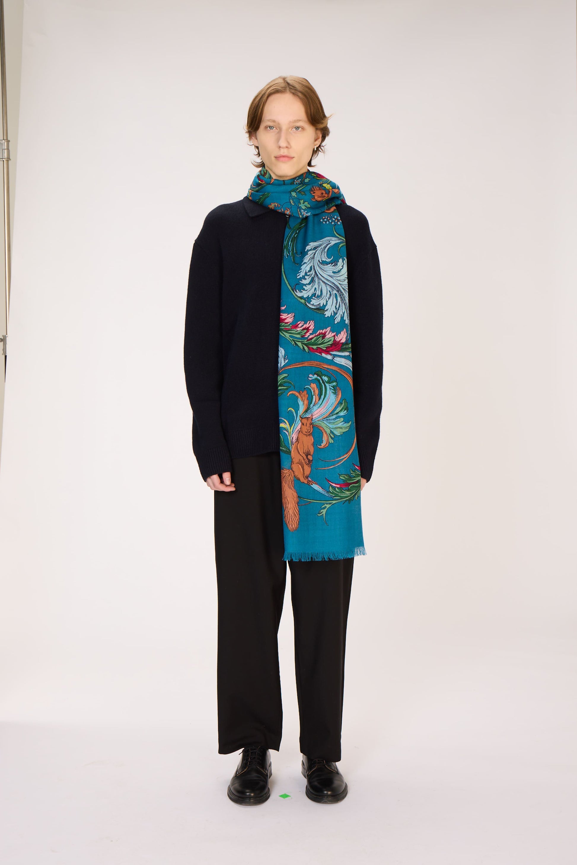 Person wearing a colorful scarf with a white background
