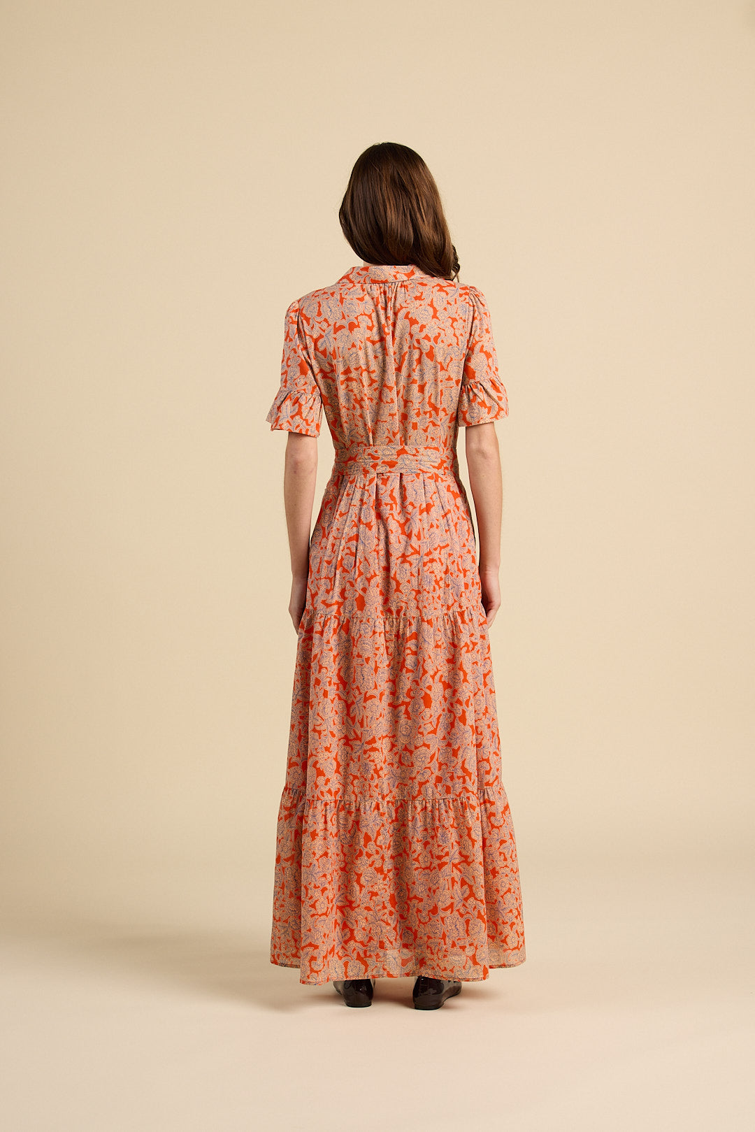 Woman wearing a floral dress on a beige background