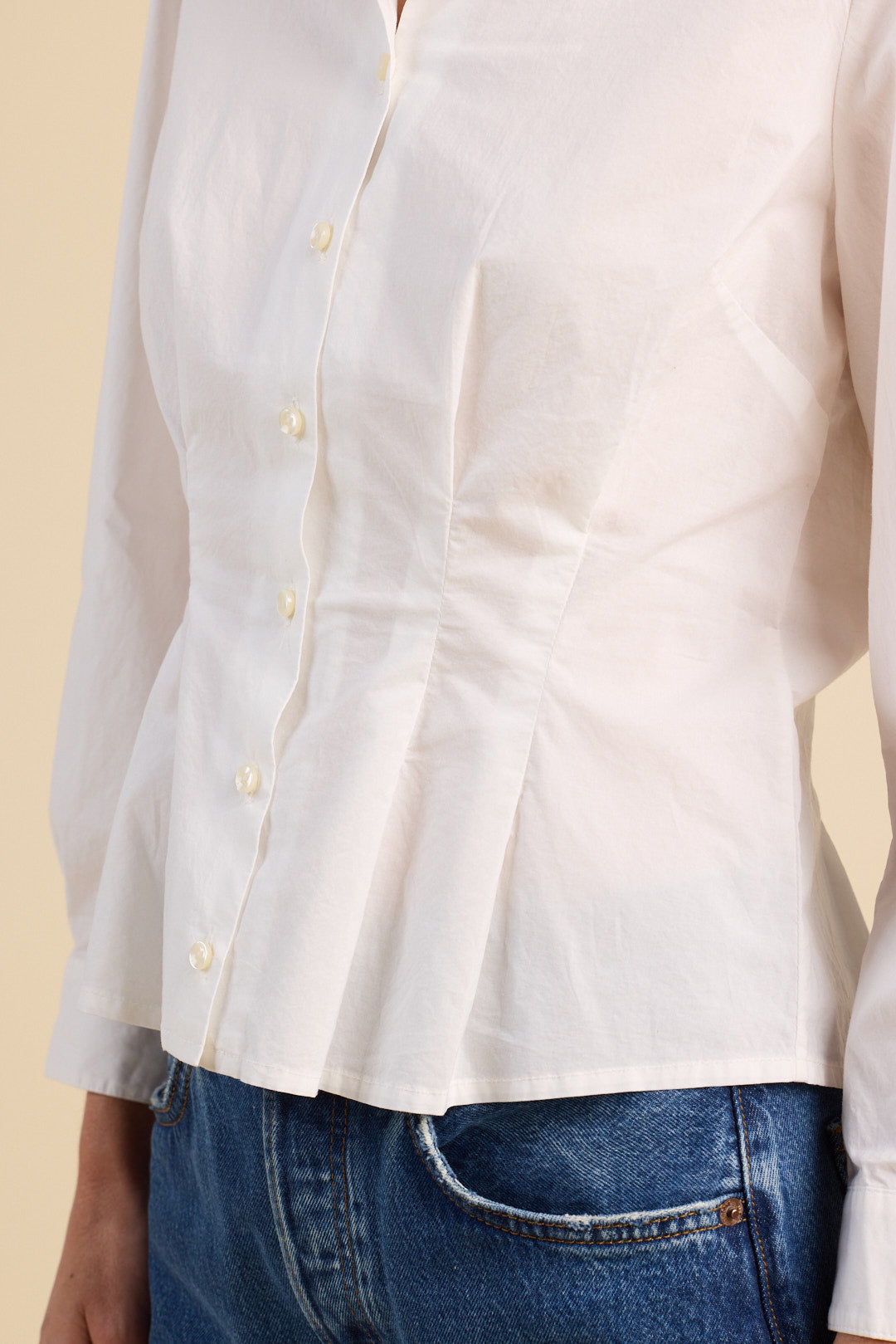 White shirt with a pleated design on a beige background