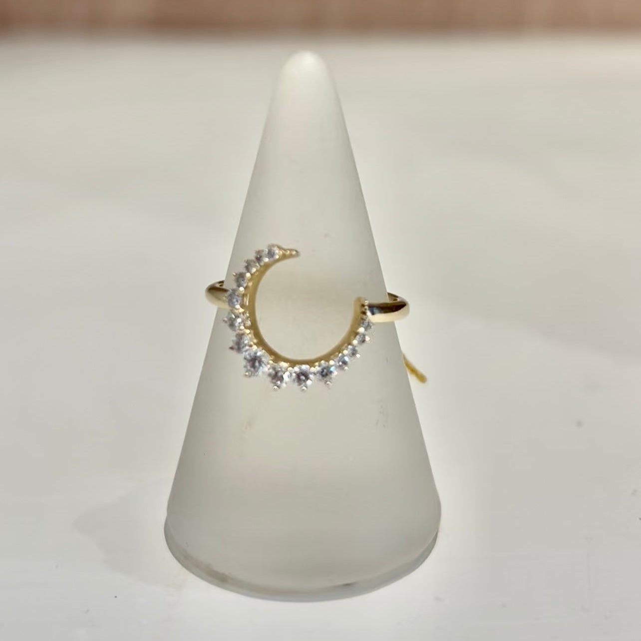 Ring on a white cone-shaped stand with a neutral background