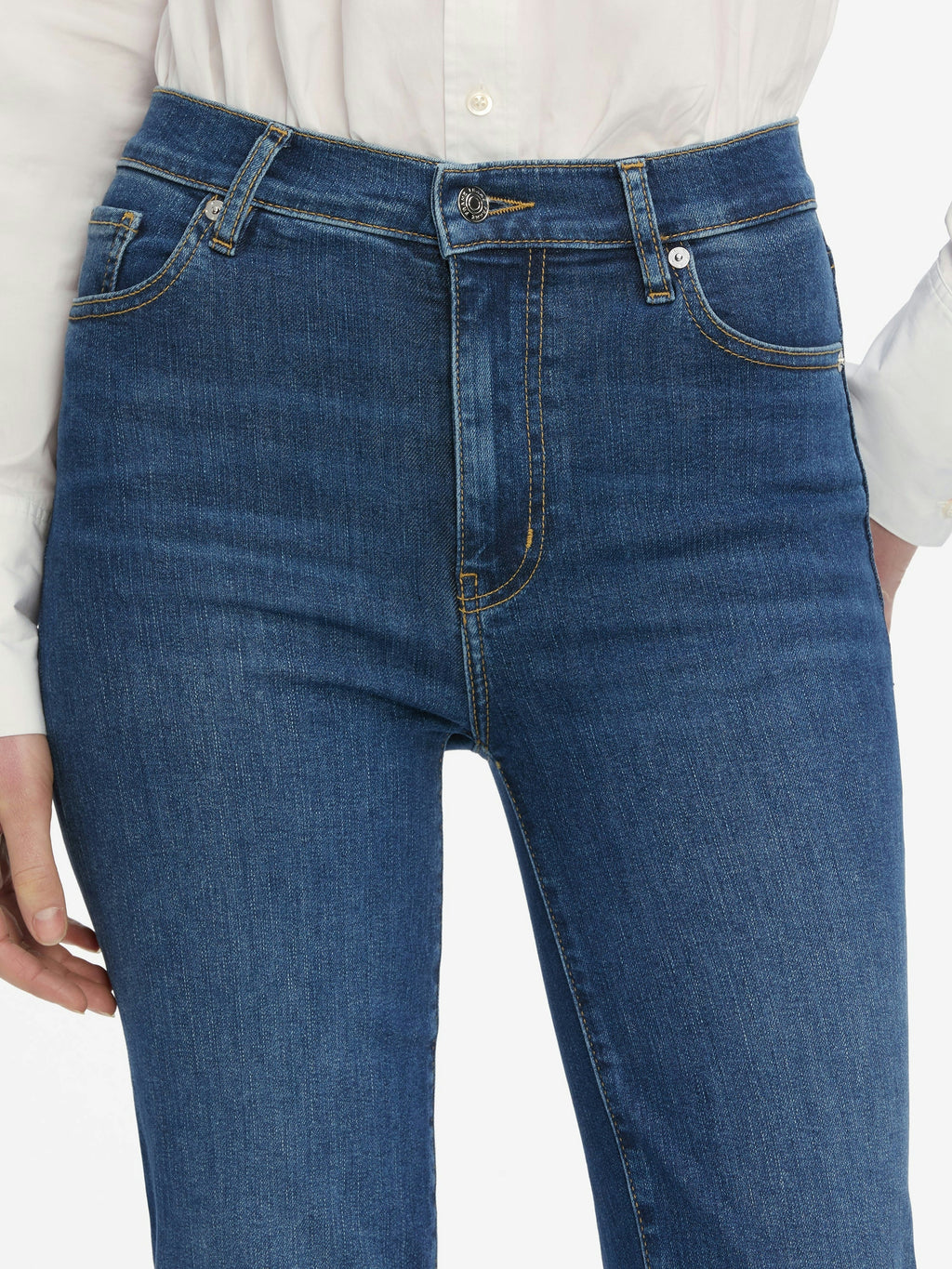 Blue jeans worn by a person on a white background