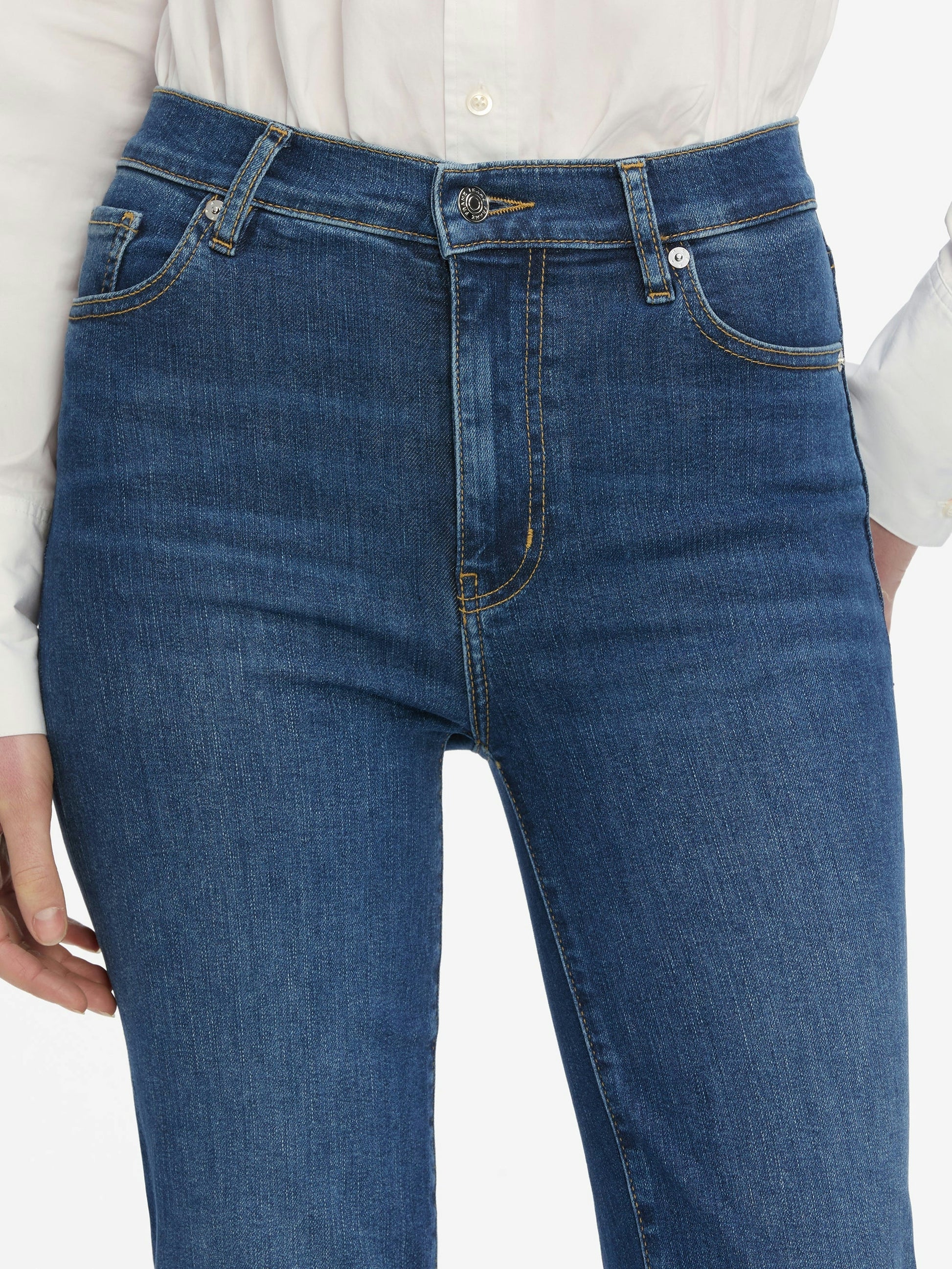 Blue jeans worn by a person on a white background