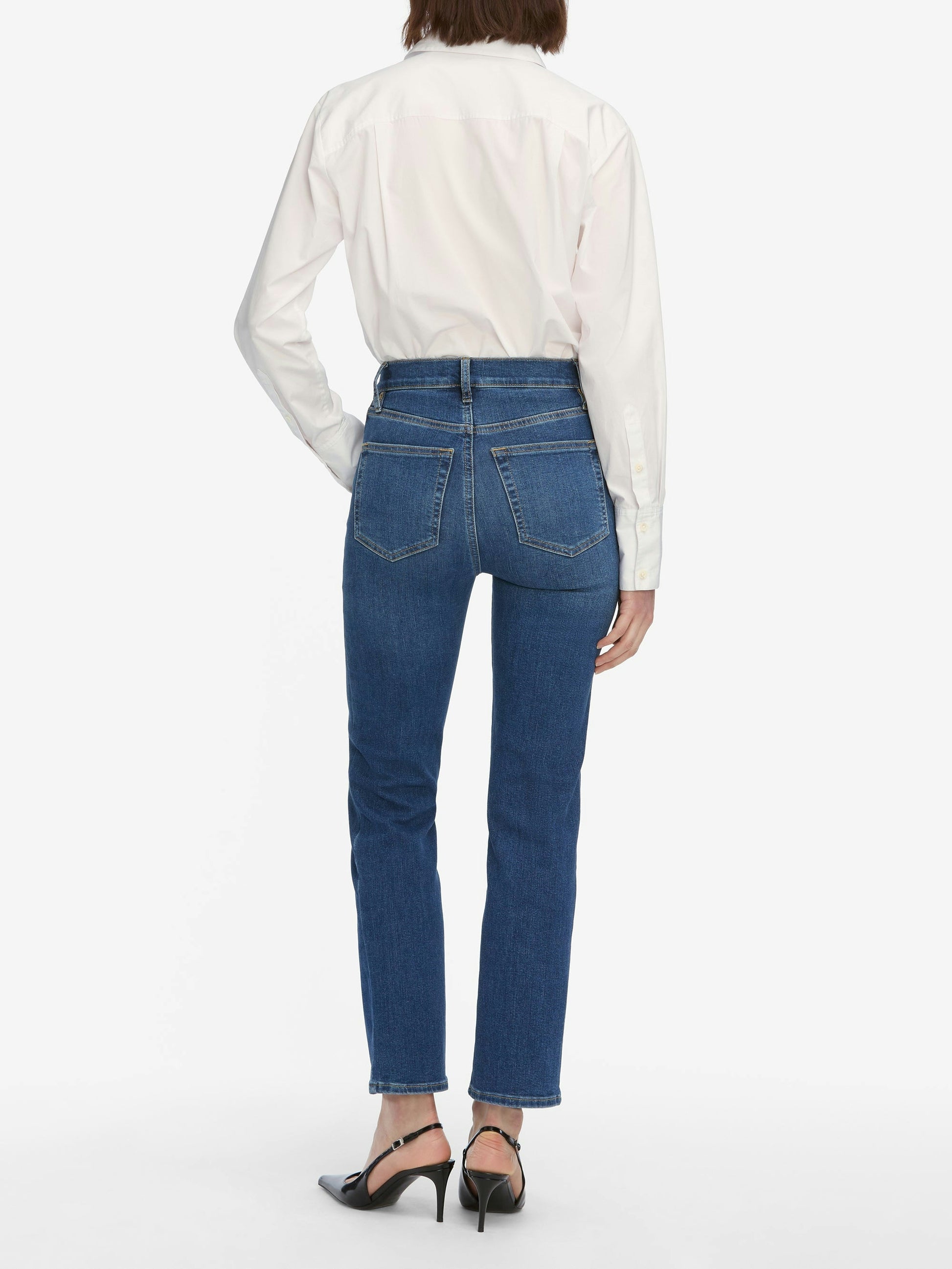 Person wearing blue jeans and a white shirt on a white background