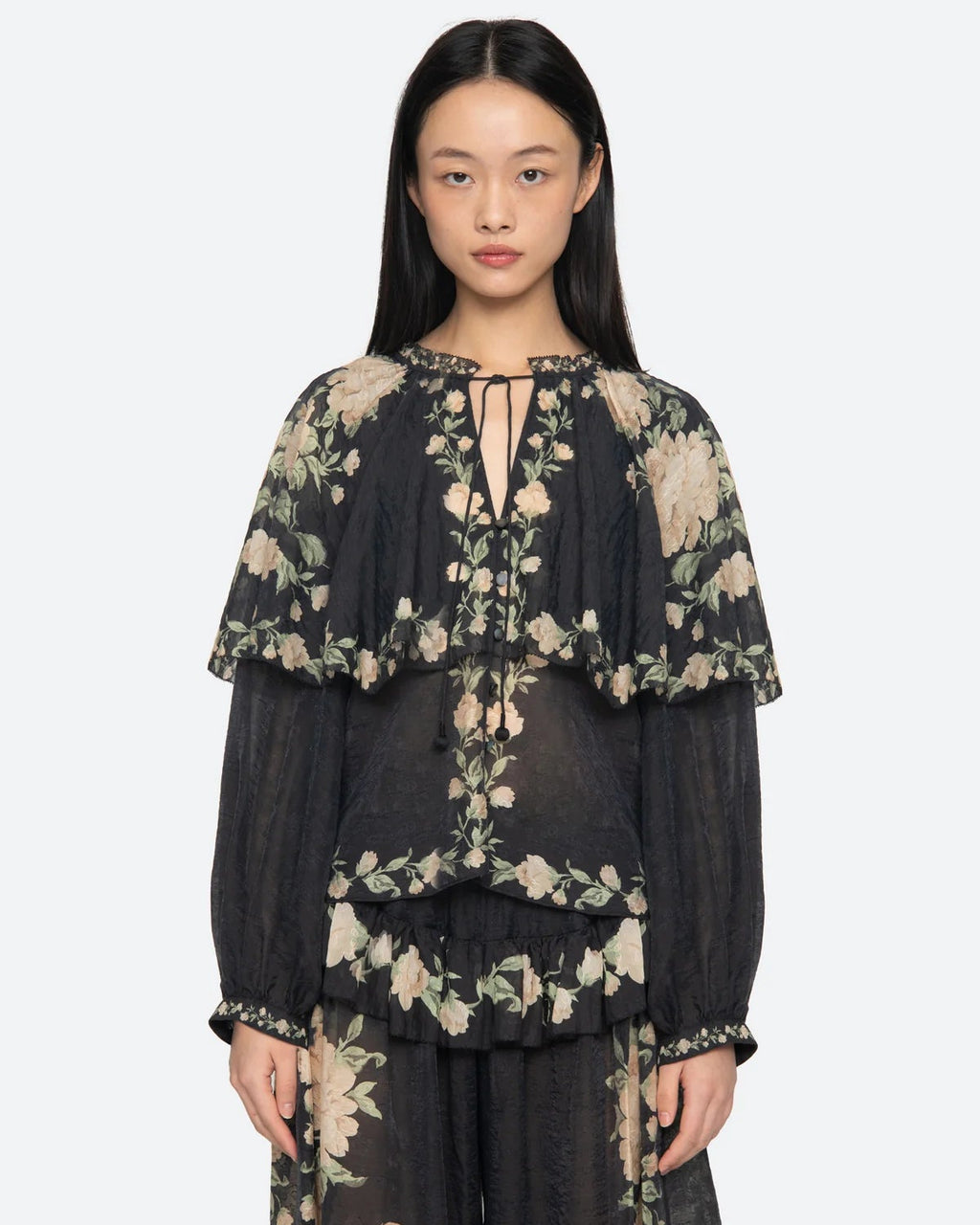 Woman wearing a black floral outfit on a white background