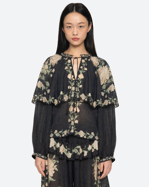 Woman wearing a black floral outfit on a white background