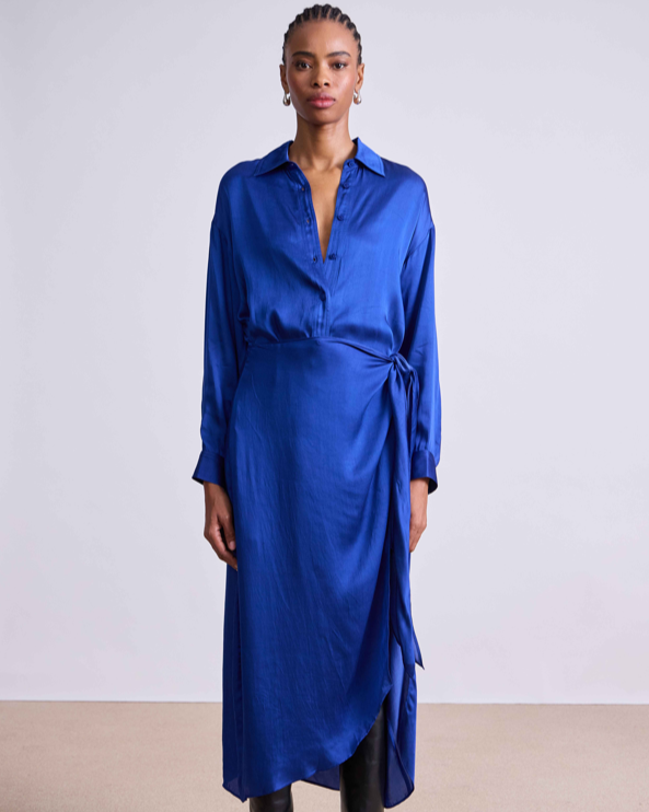 Woman wearing a blue dress with a plain background