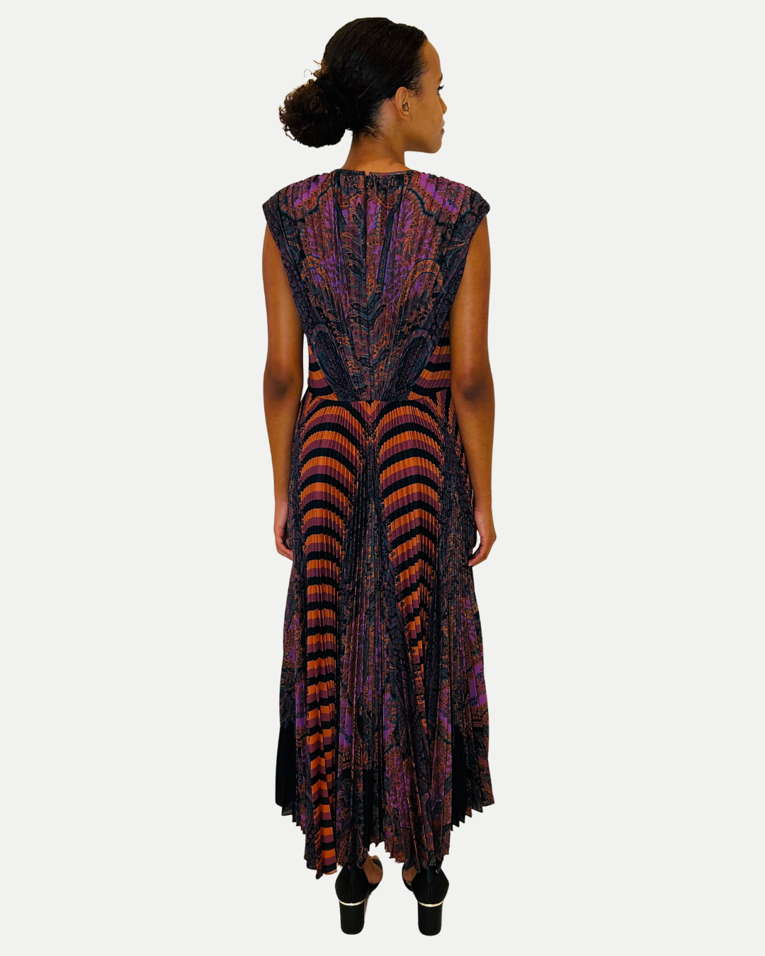 Woman wearing a long, patterned dress on a white background