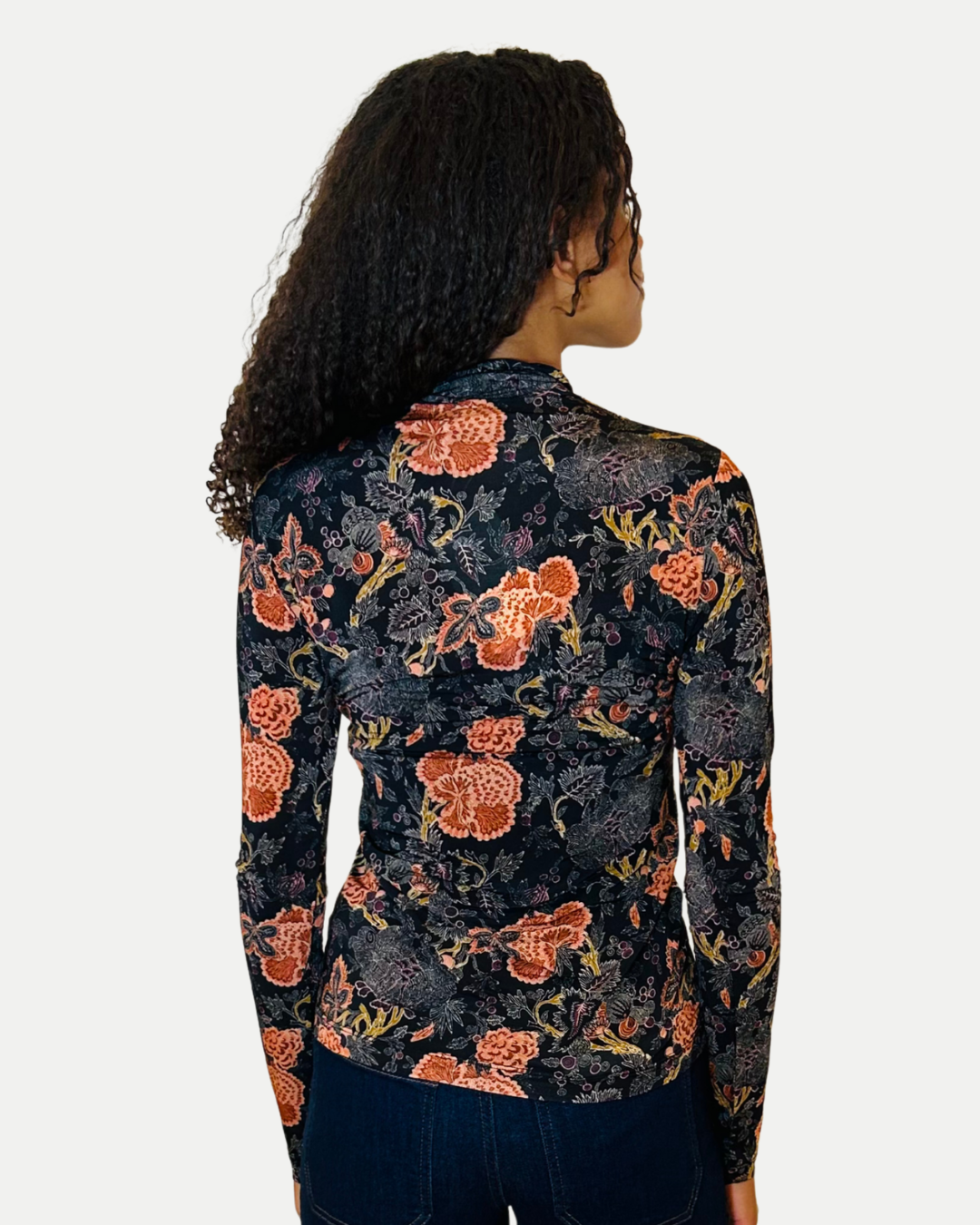 Woman wearing a floral patterned shirt with a white background