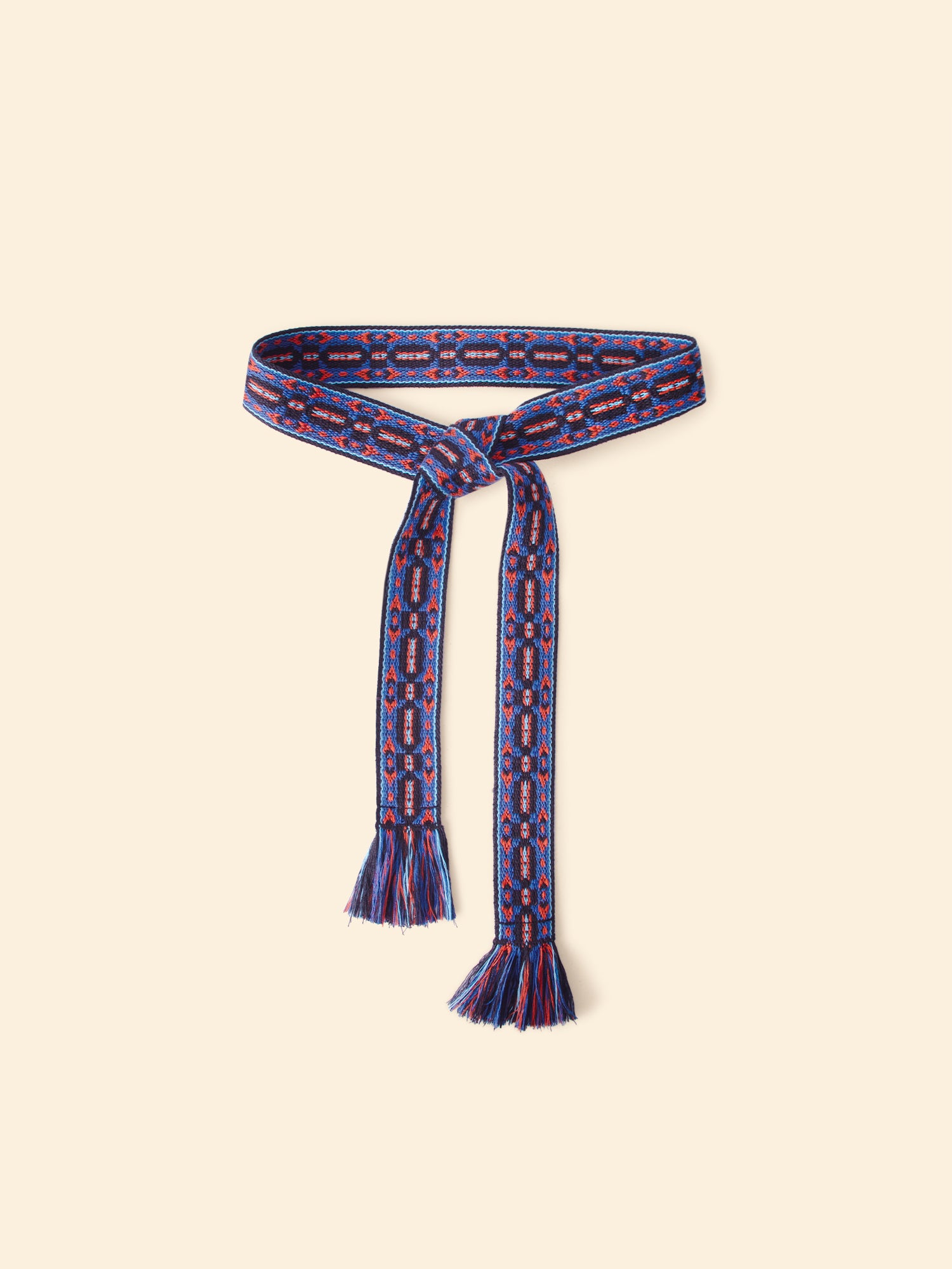 Blue patterned belt with tassels on a beige background