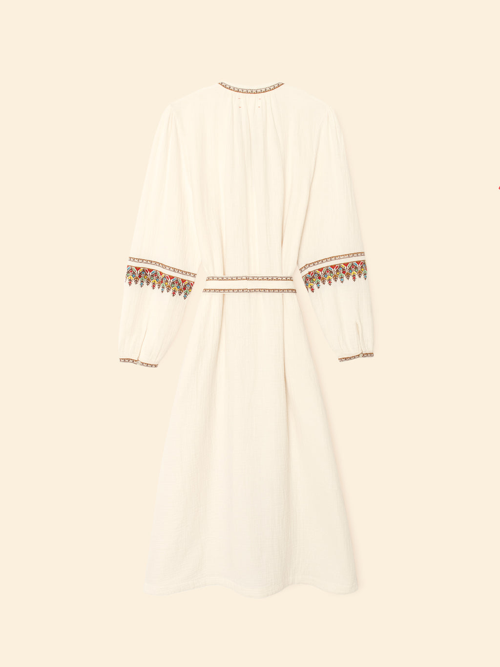 White dress with embroidered details on a beige background