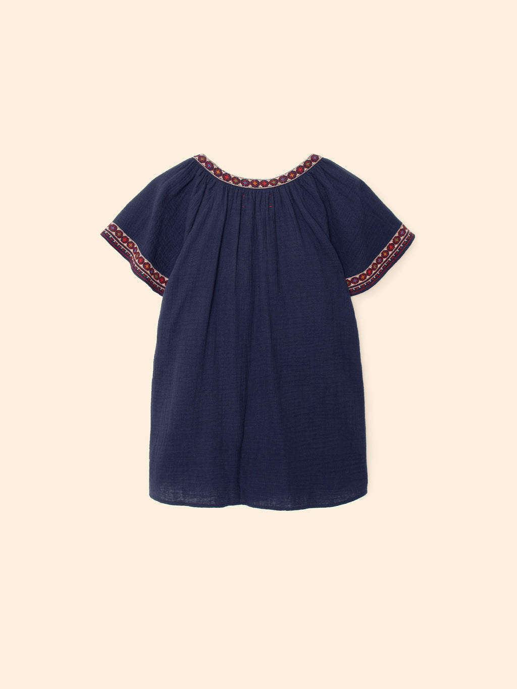 Navy blue dress with red trim on a beige background