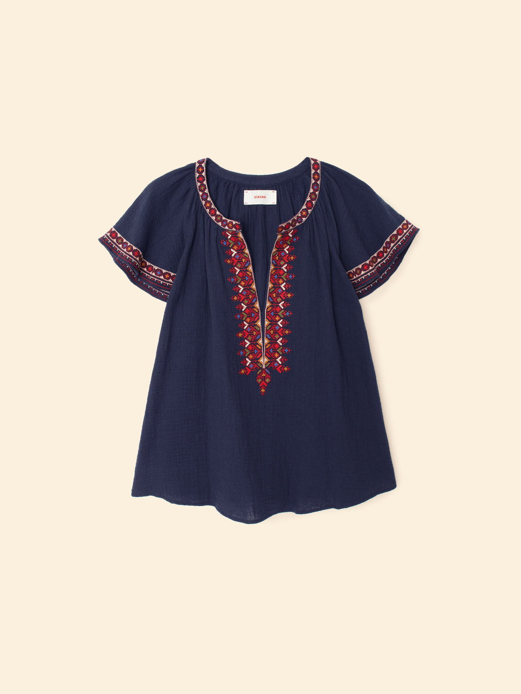 Navy blue blouse with red embroidery on a beige background