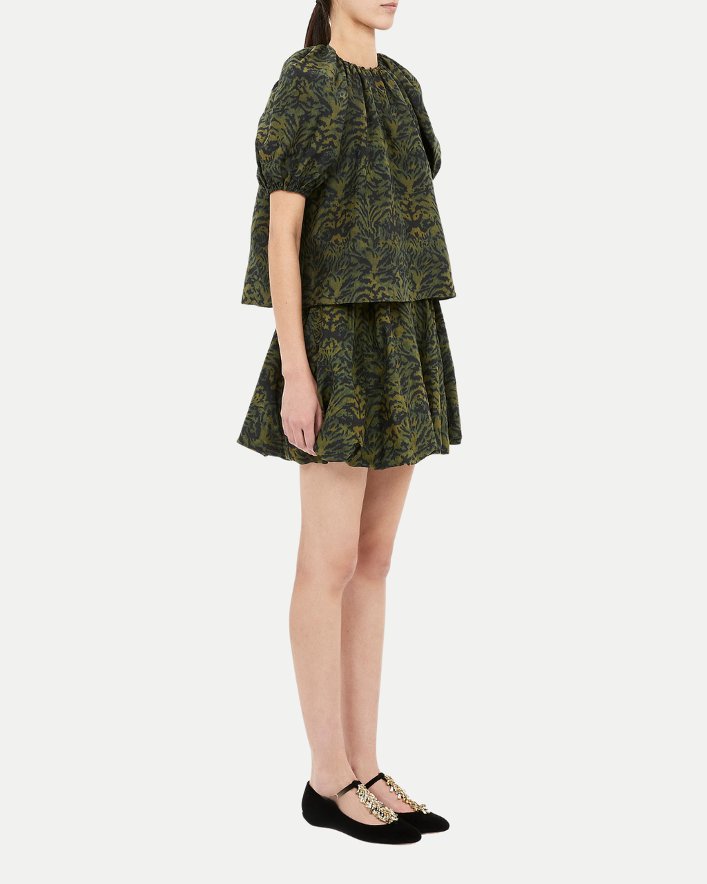 Woman wearing a green patterned outfit on a white background