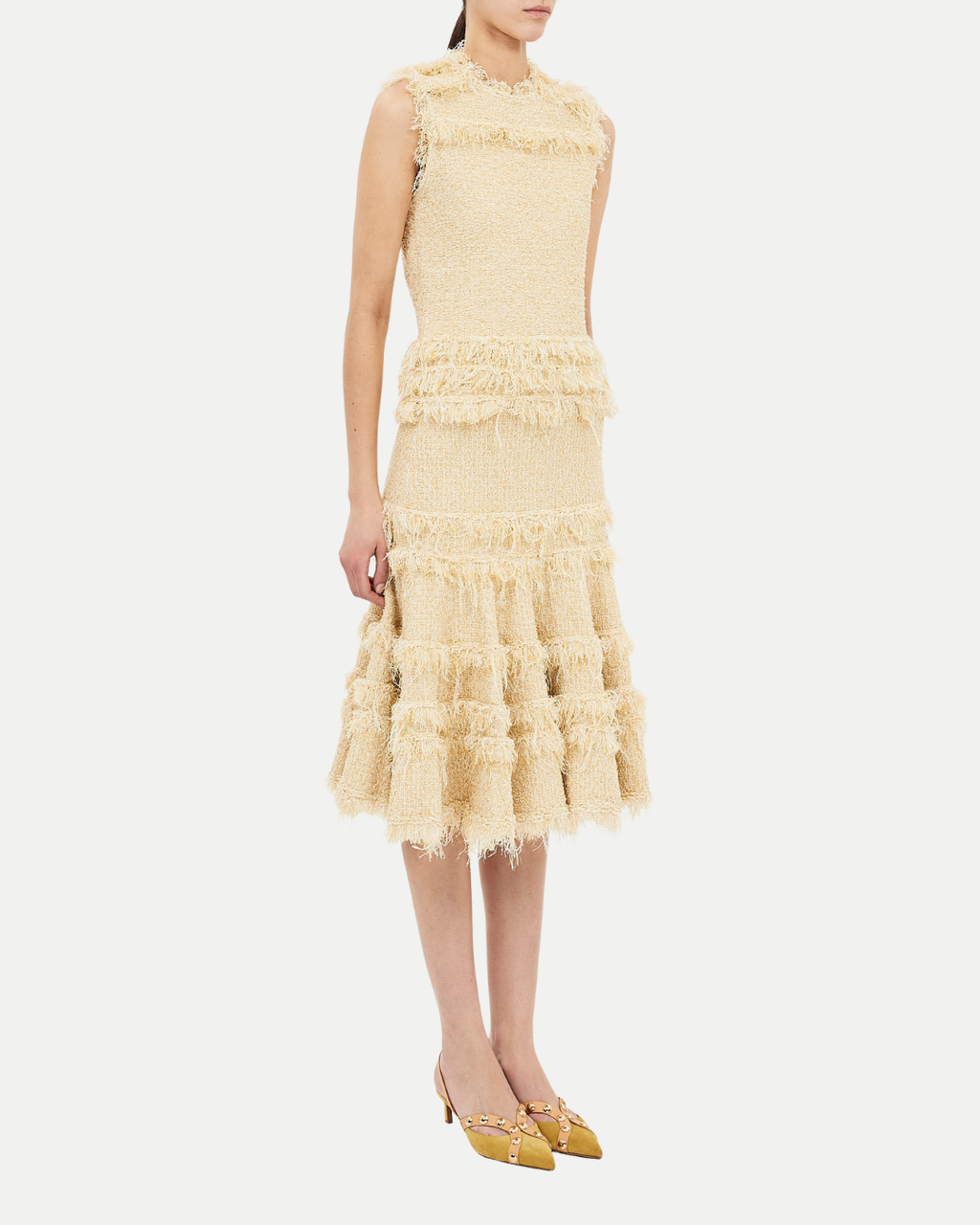 Woman wearing a light yellow lace dress on a white background