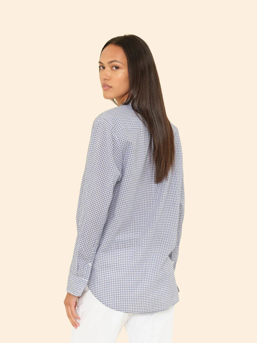 Woman wearing a blue checkered shirt on a beige background